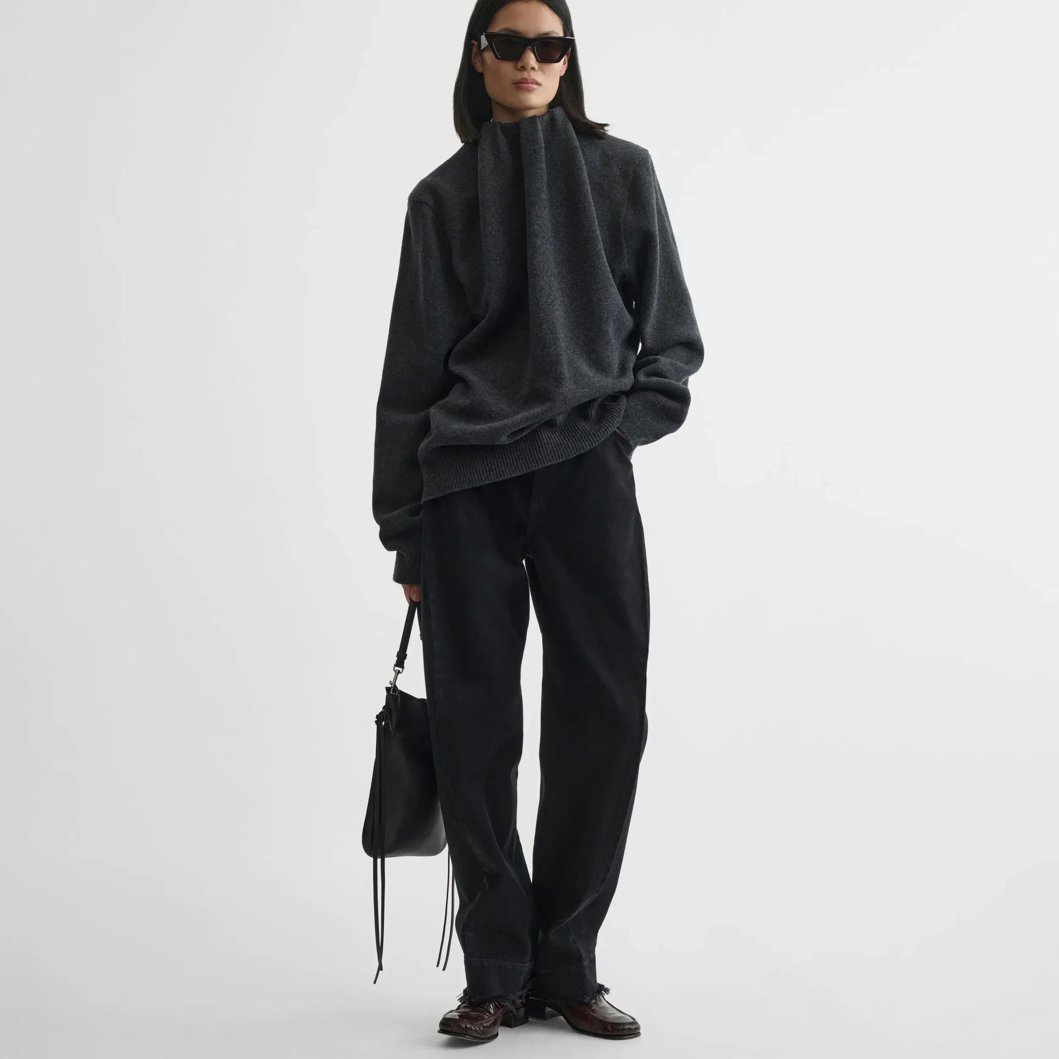 Front view of model holding gig pouch in black leather with silver.