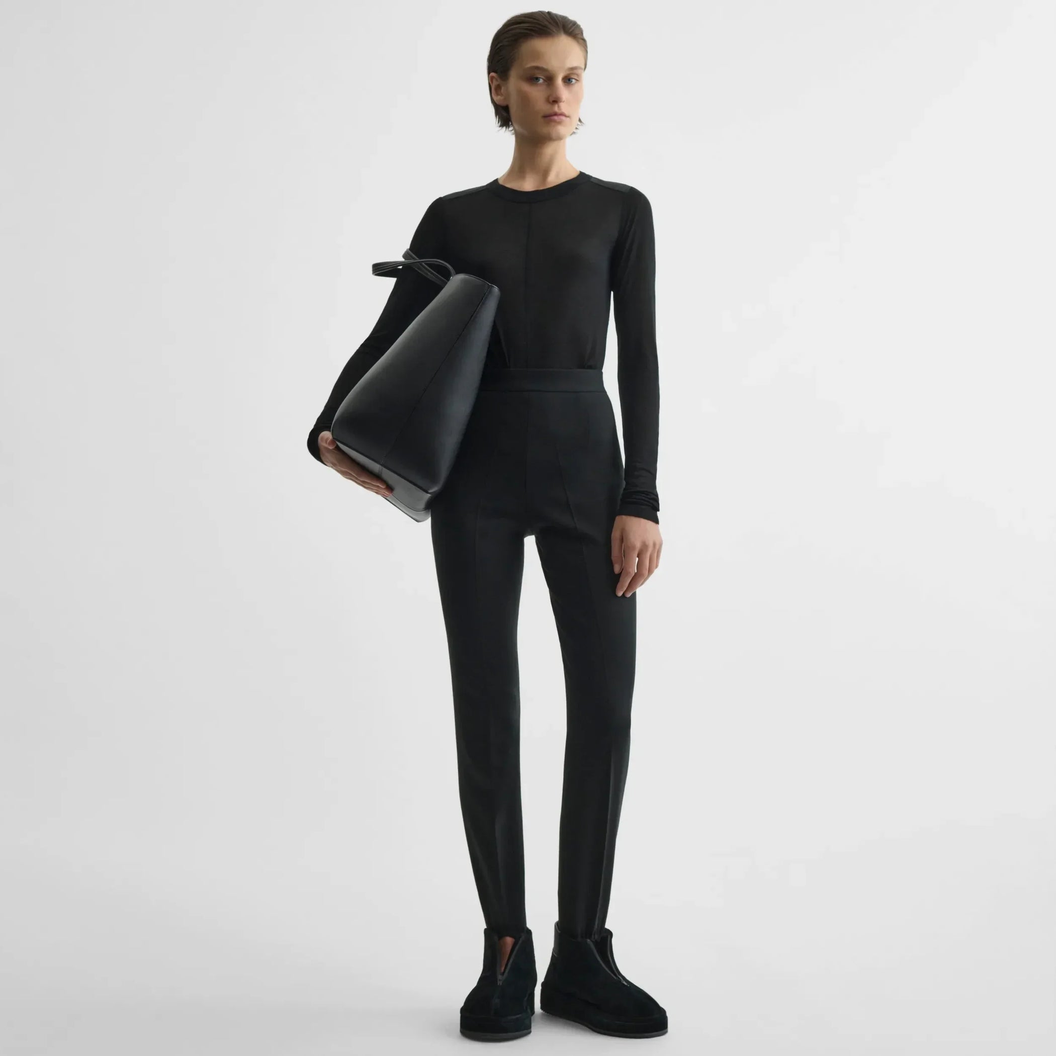 Front view of model holding pot cabas in black leather.