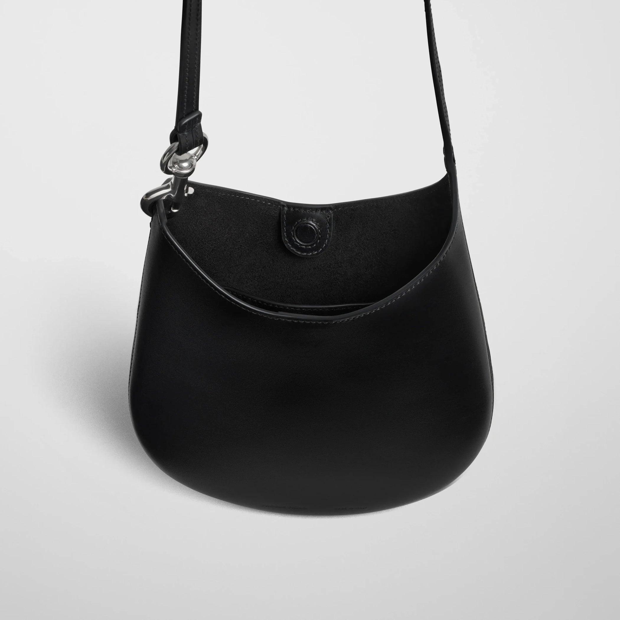 Close up detail view of mini bean sling in black leather.