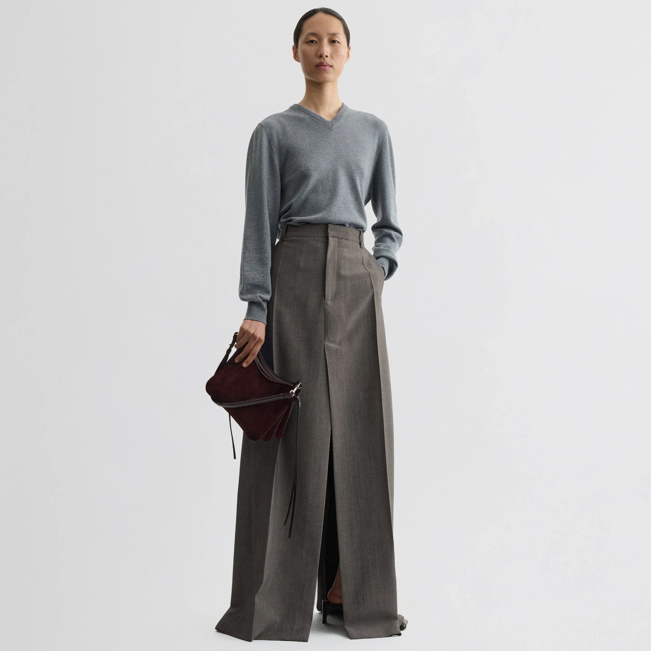 Front view of model wearing small gig bag in oxblood suede leather.