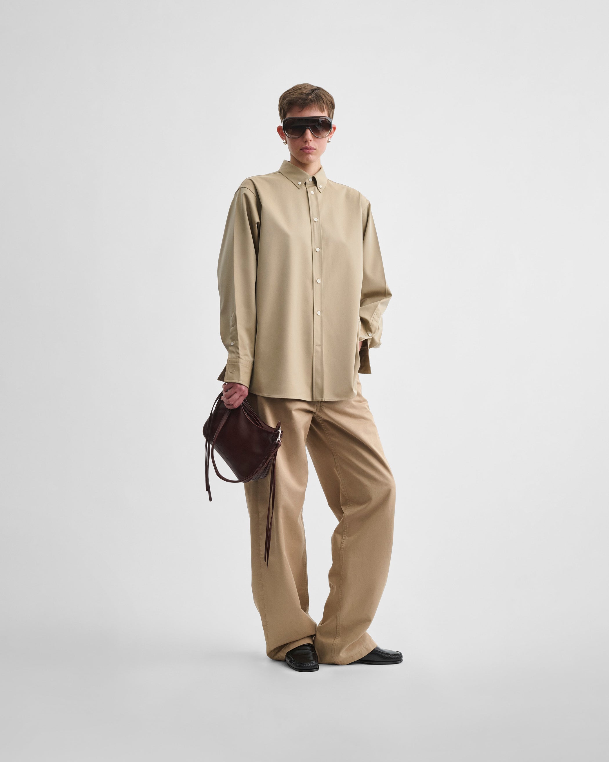 Model holding SMALL GIG BAG in cognac leather