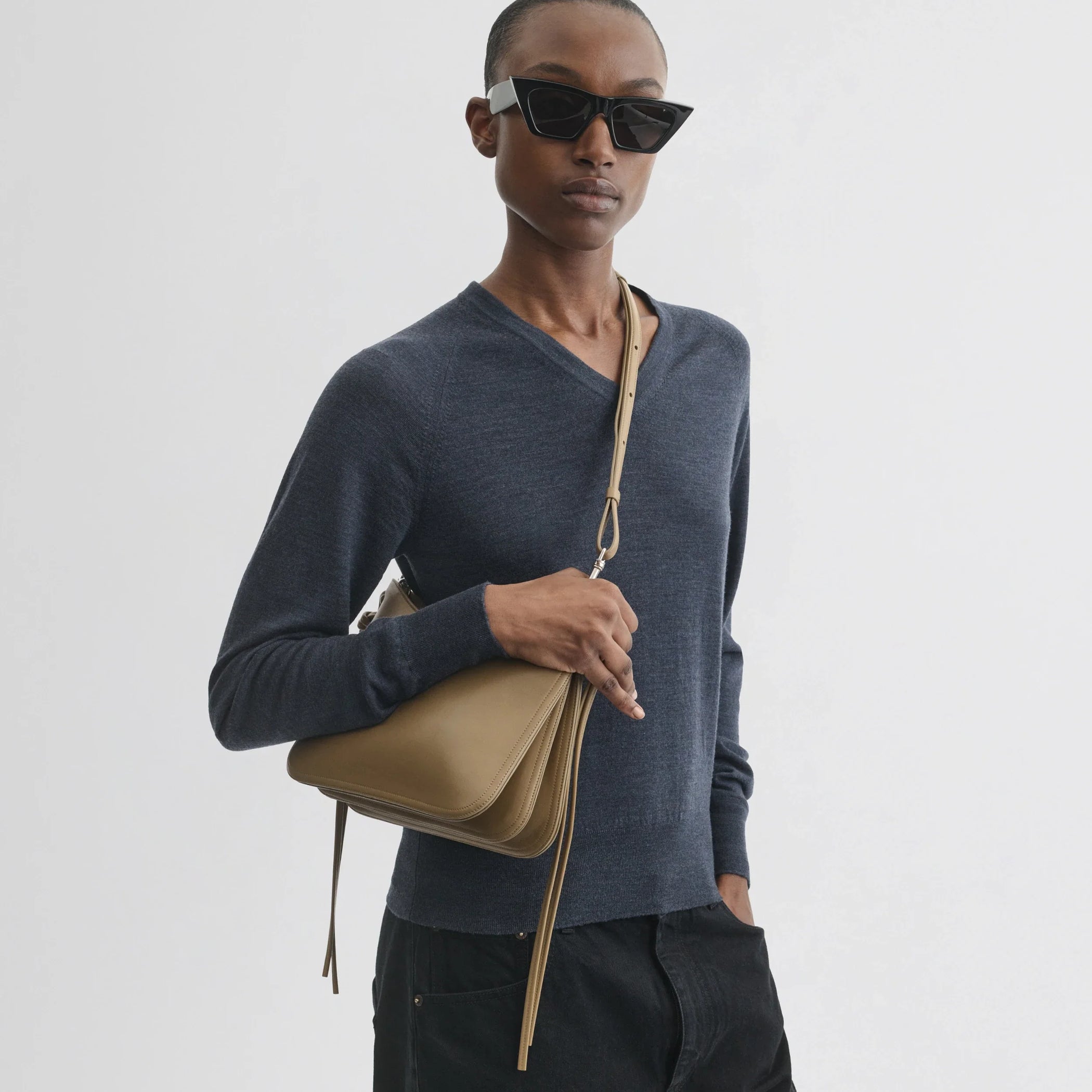Front view of model wearing small gig bag in cookie leather.
