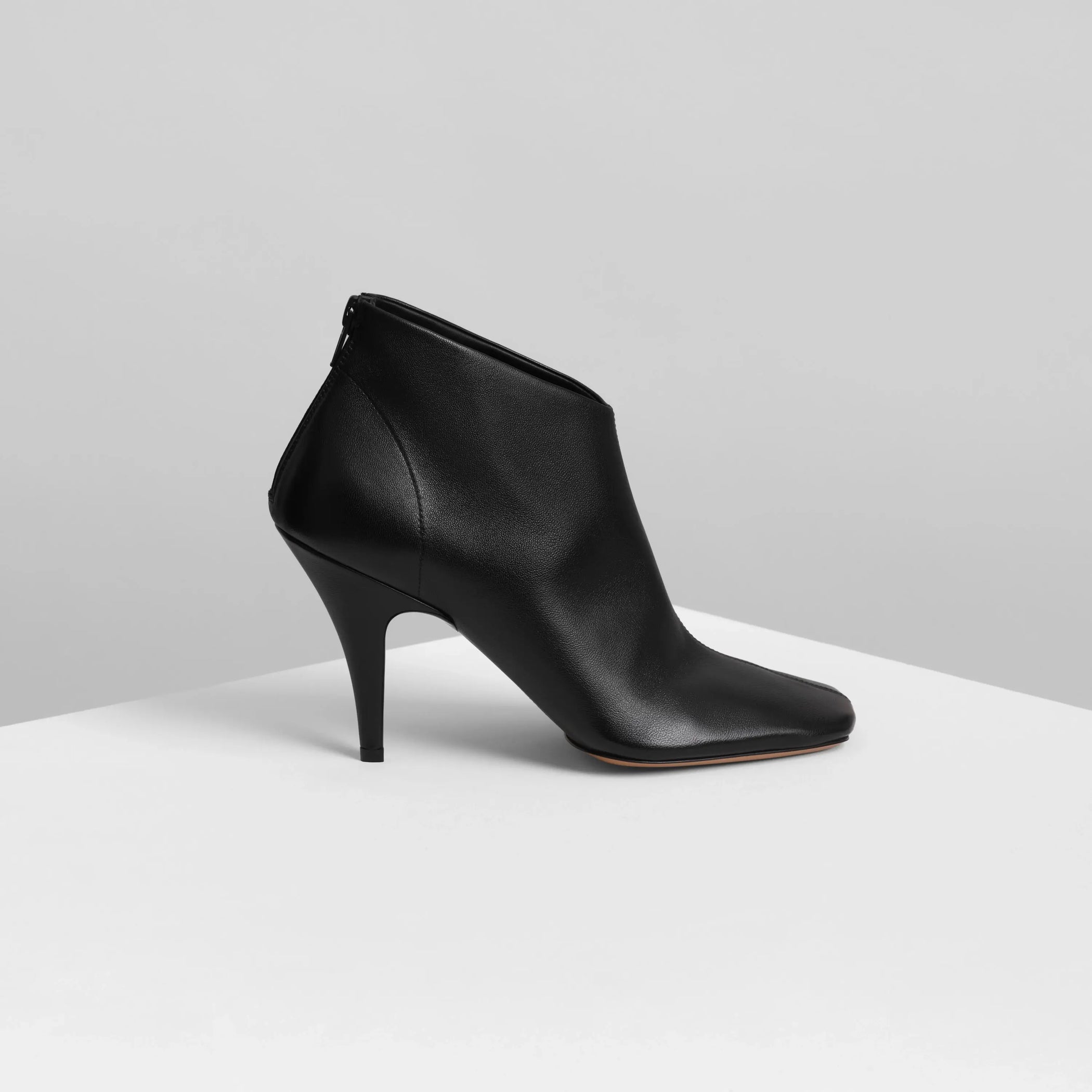 Side view of soft ankle boot 90 in black leather.
