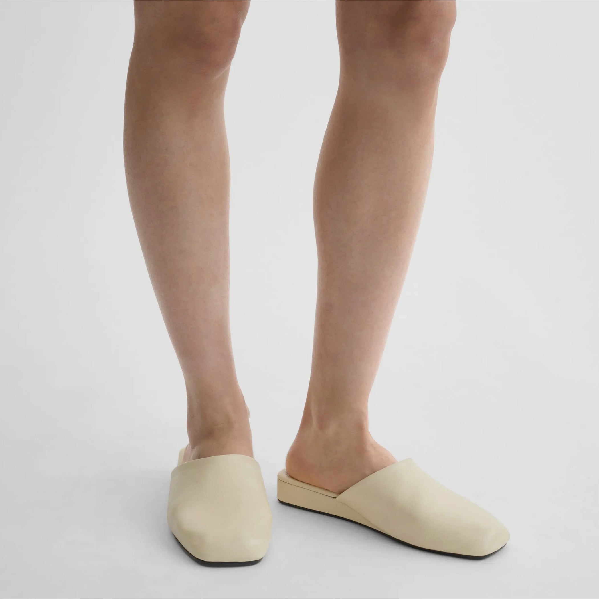 Front view of model wearing robe slide in cream leather.
