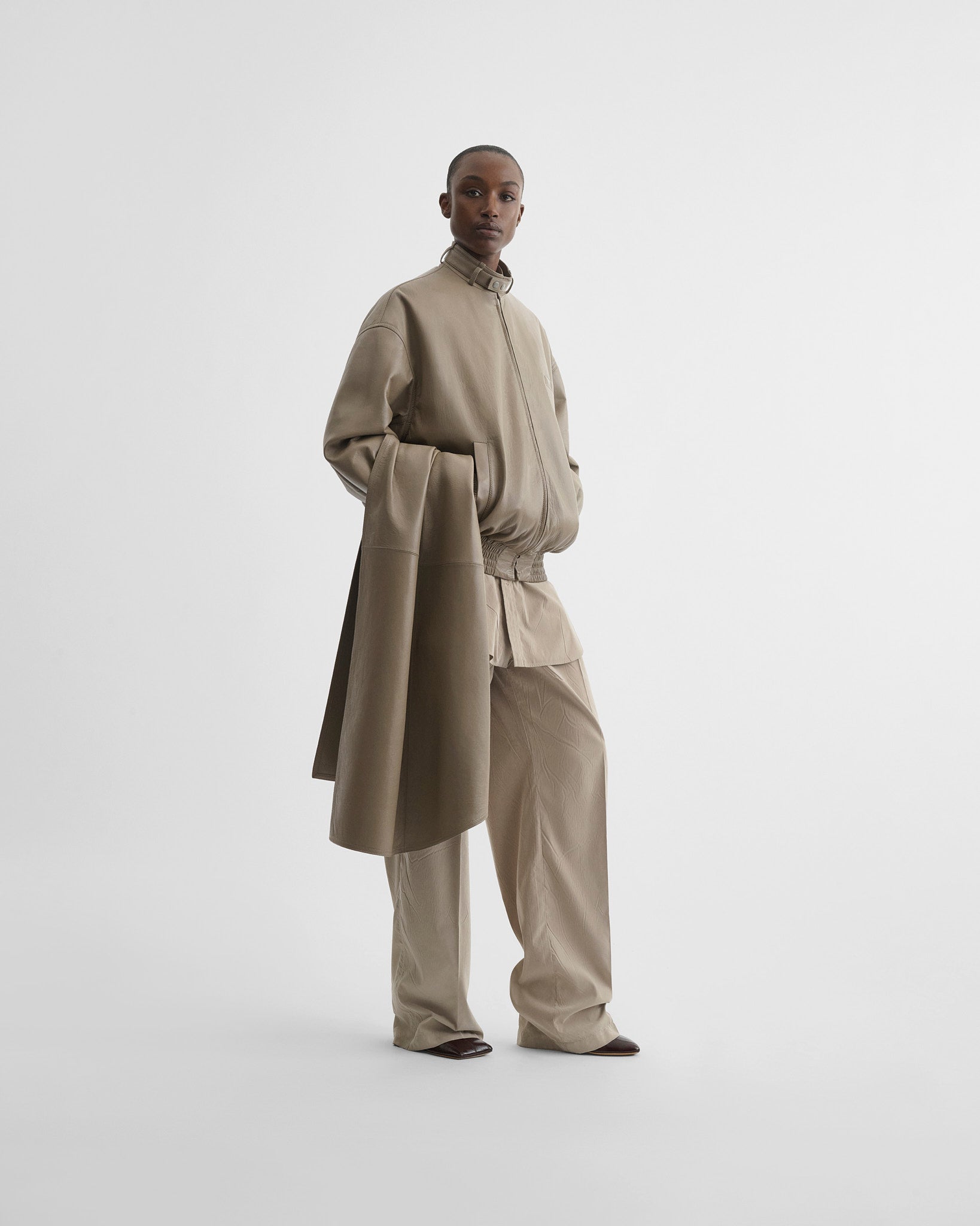 Front view of model wearing jacket with attachable scarf in mastic leather