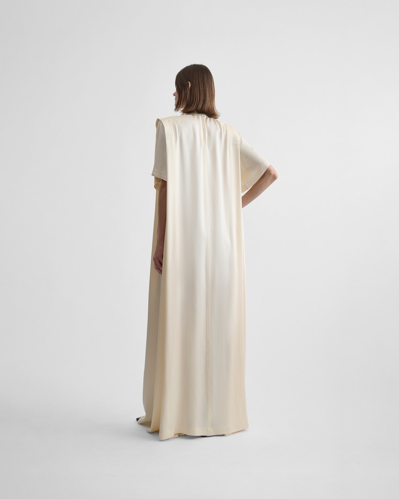 Close up front view of folded shoulder dress in vanilla satin back crepe