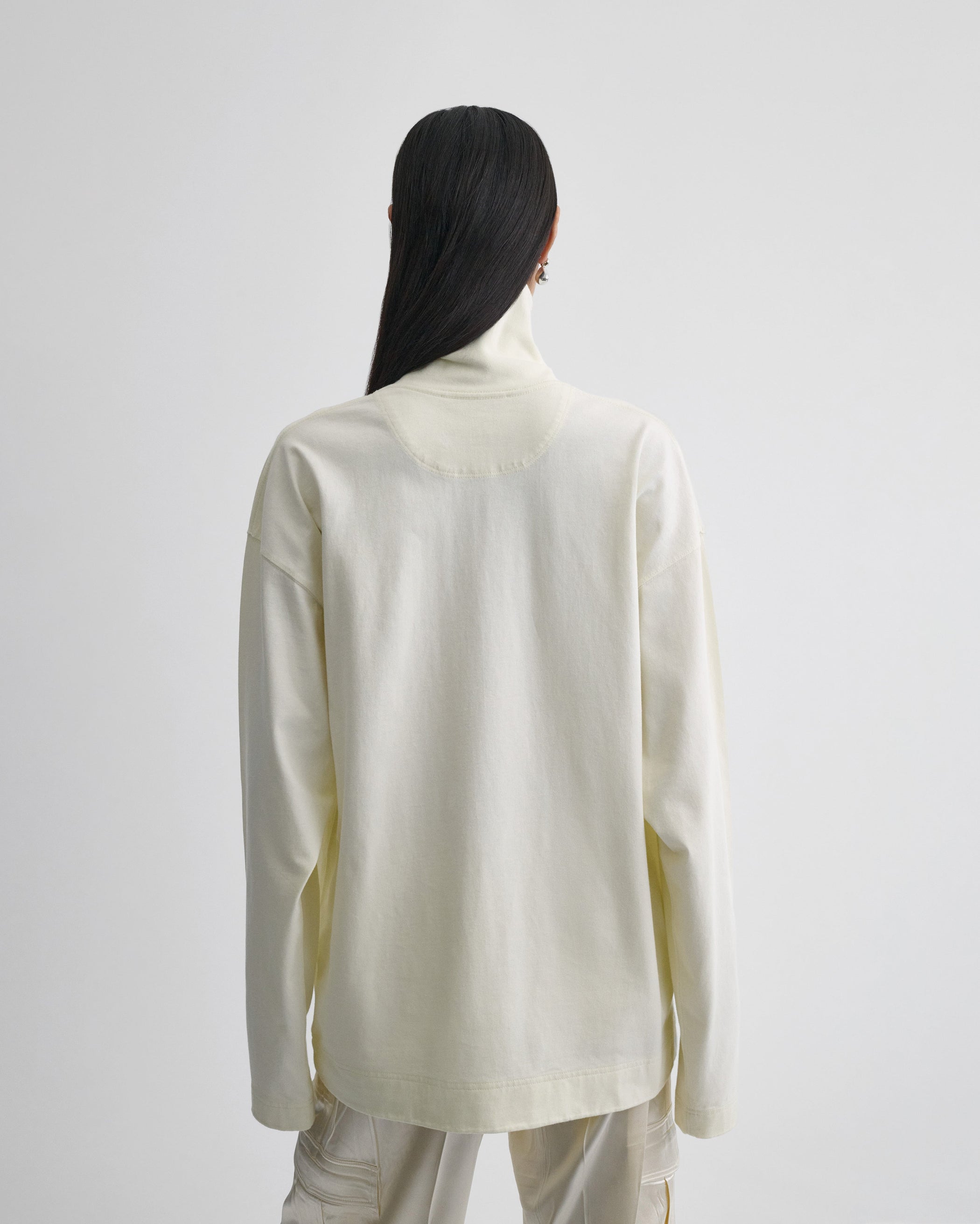 Back view of model wearing RELAXED LONG SLEEVE JERSEY in cream cotton jersey