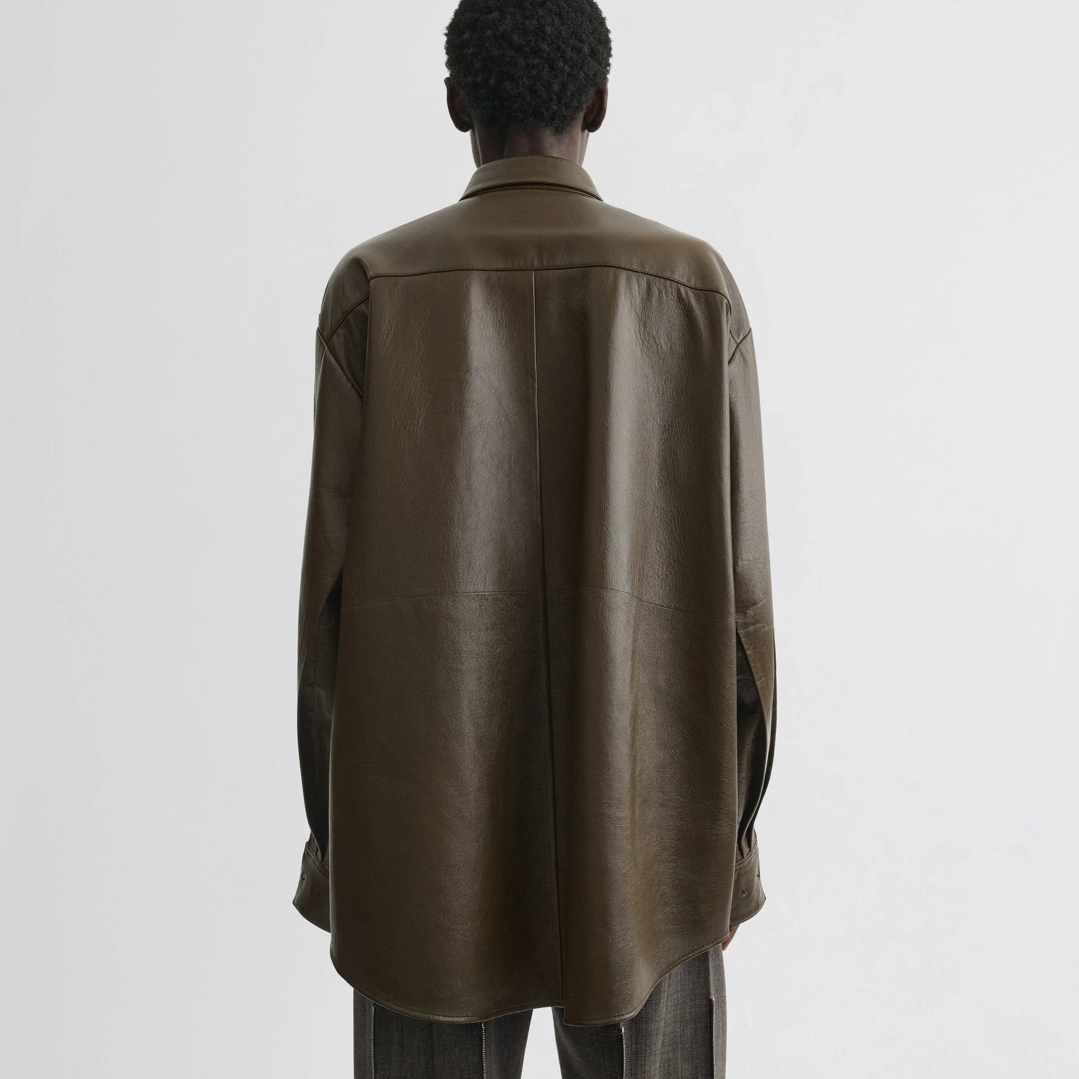 Back view of model wearing overshirt in green bronze leather.