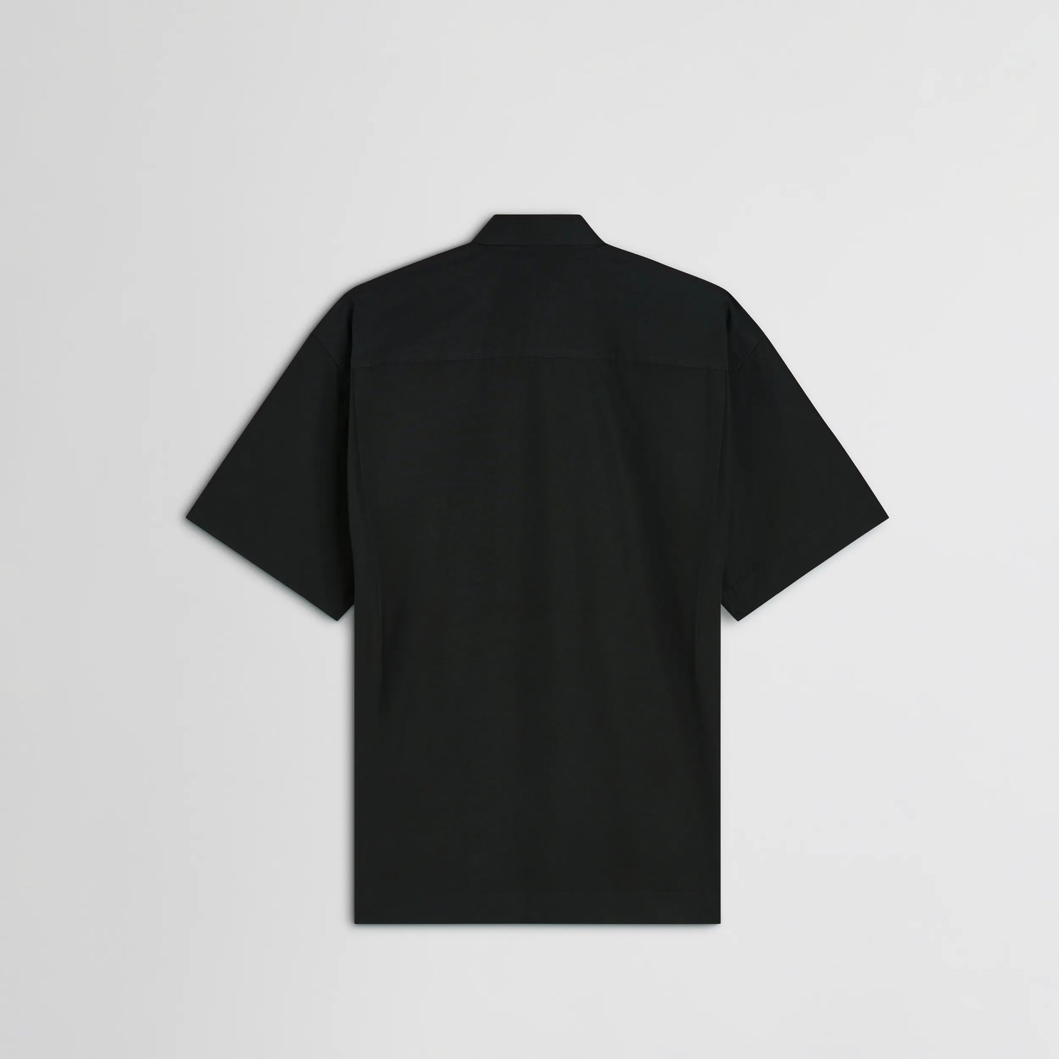 Flat back view of short sleeve shirt in black cotton