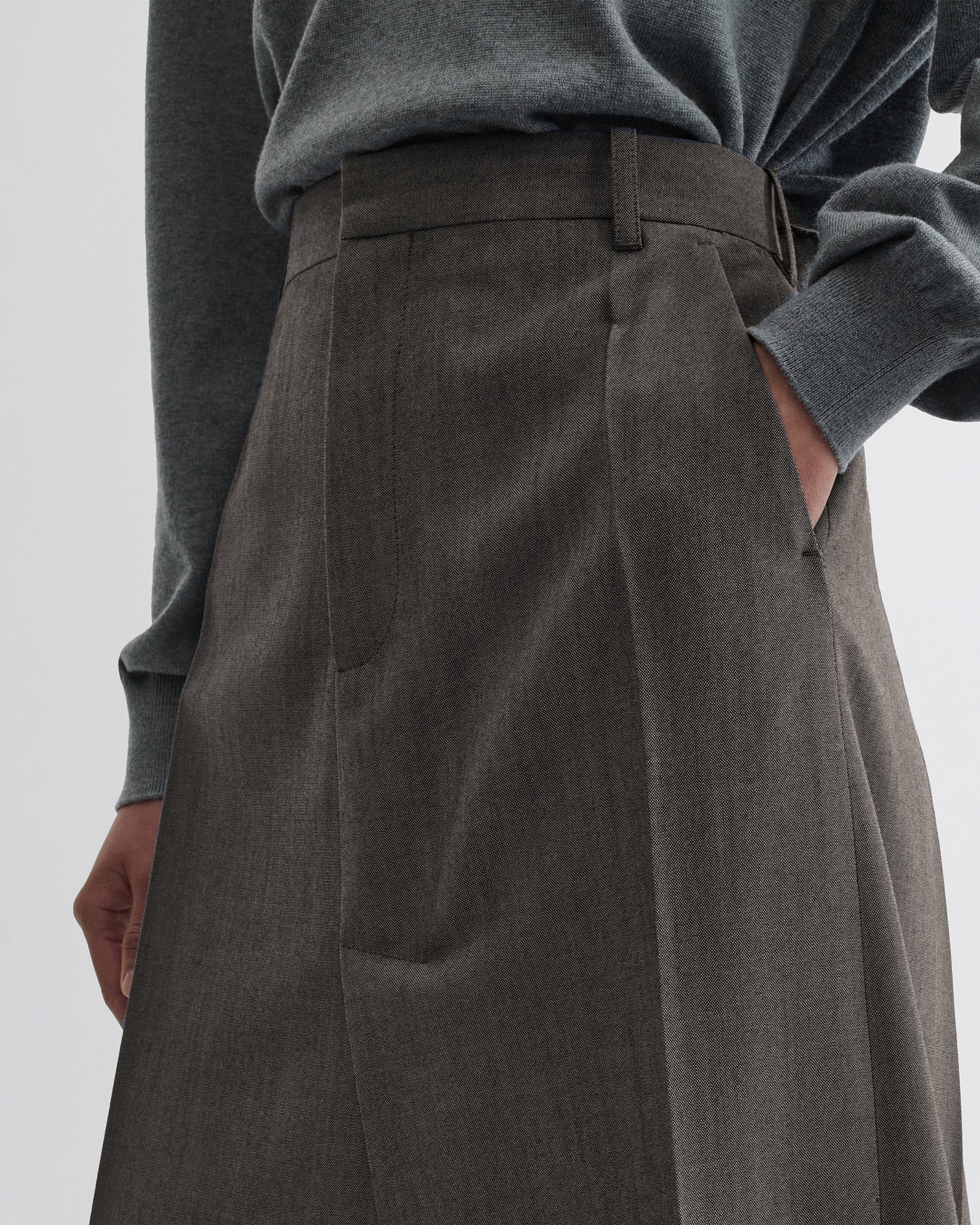 Close up detail view of double slit tailored skirt in dark taupe wool.