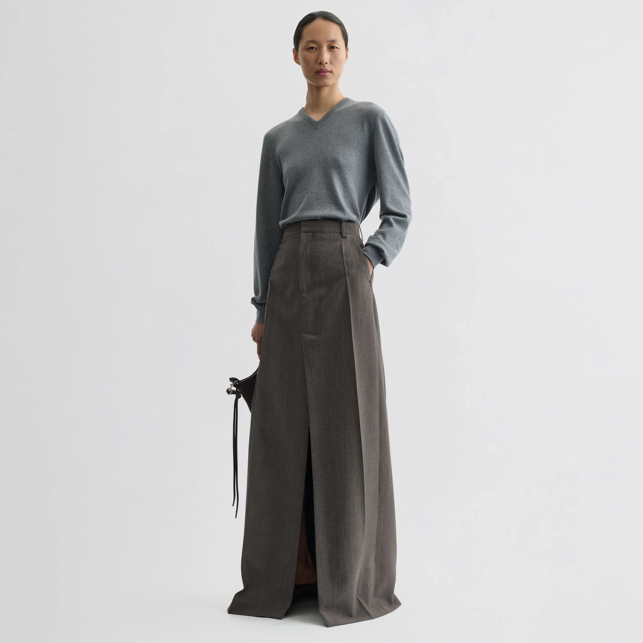 Front view of model wearing double slit tailored skirt in dark taupe wool.