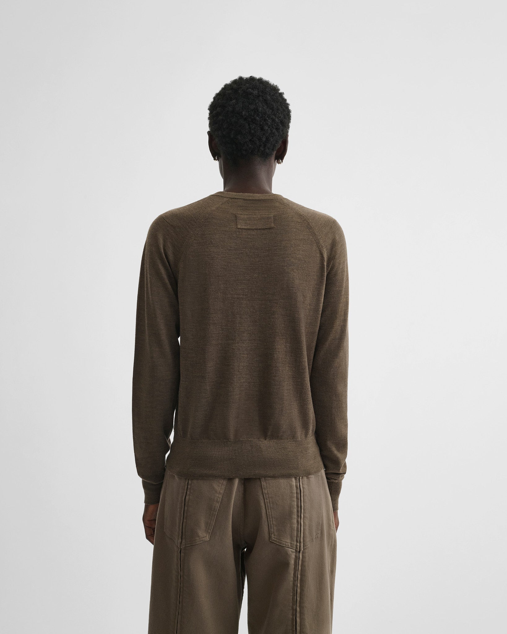 Back view of model wearing shrunk v-neck in taupe wool