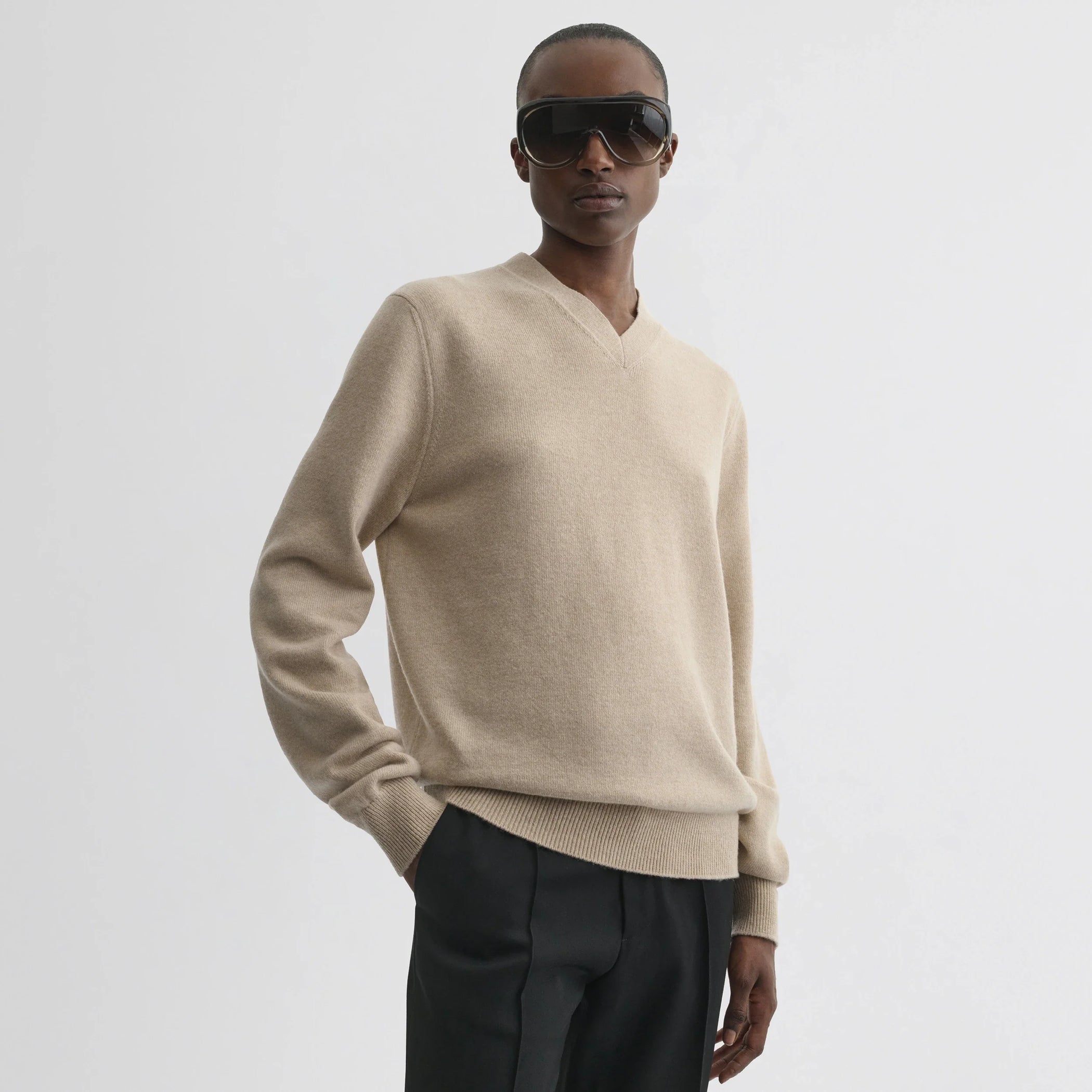 Front view of model wearing easy v-neck sweater in beige wool cashmere.