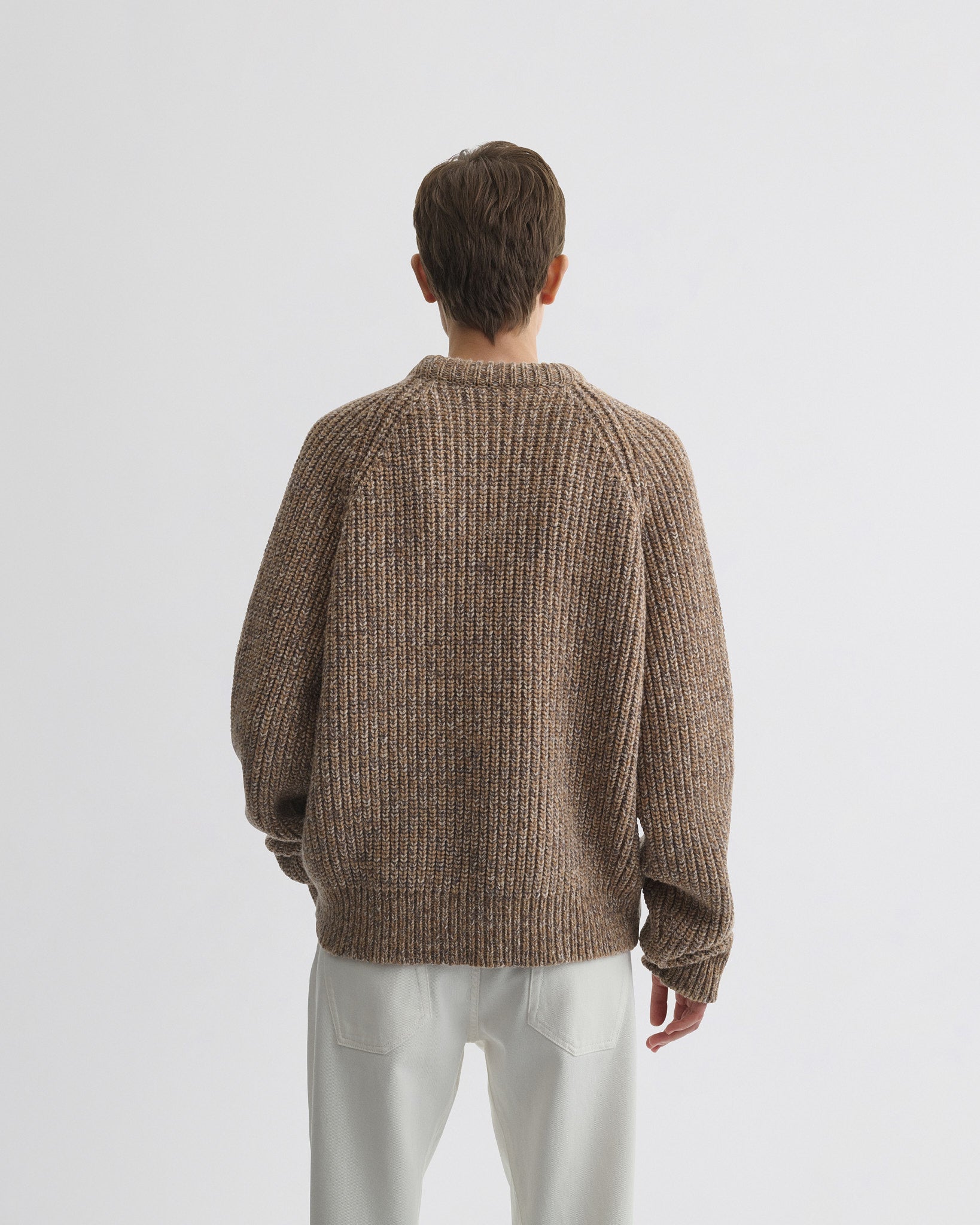 Back view of model wearing mouline jumper in camel wool.