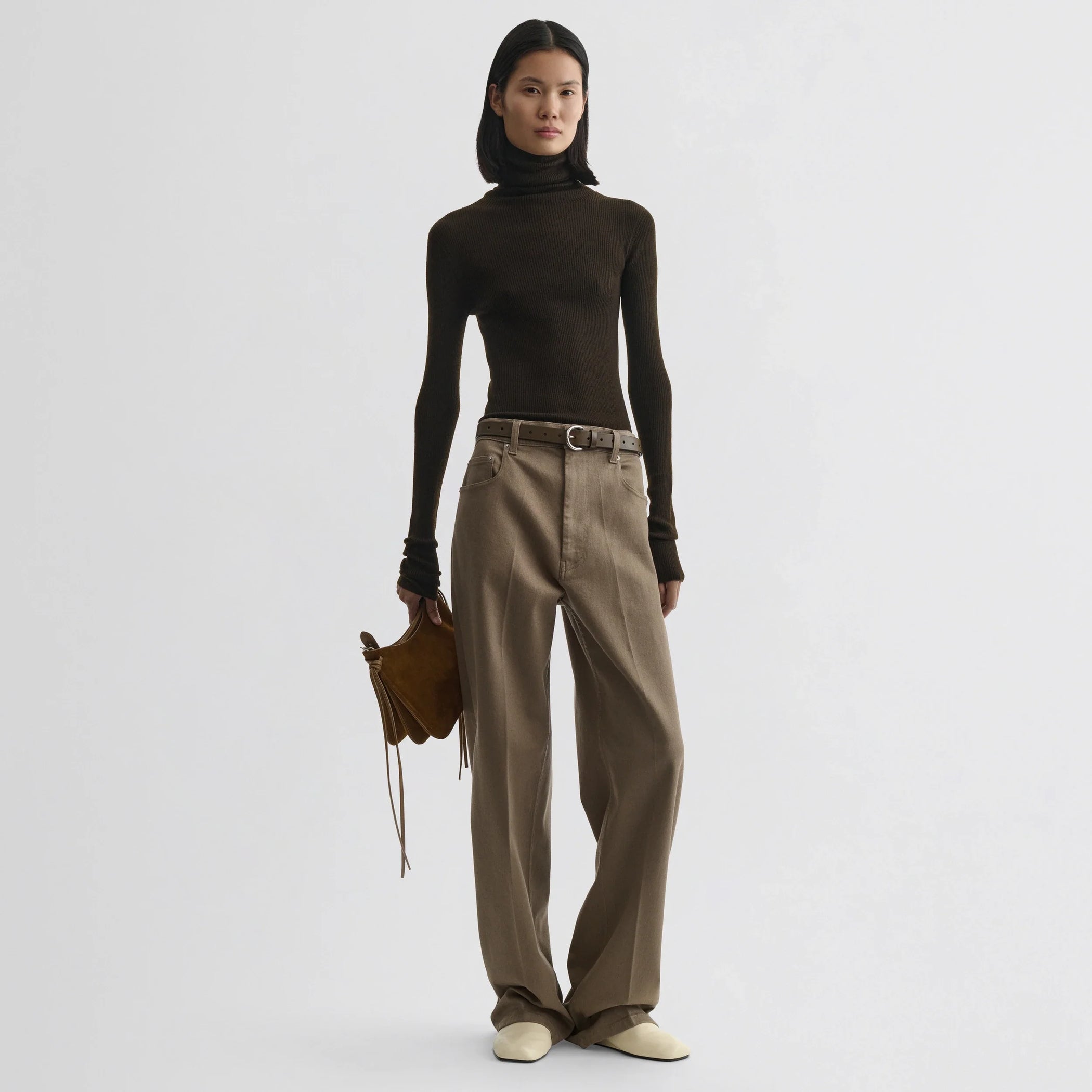 Front view of model wearing fine rib high neck top in dark khaki wool.