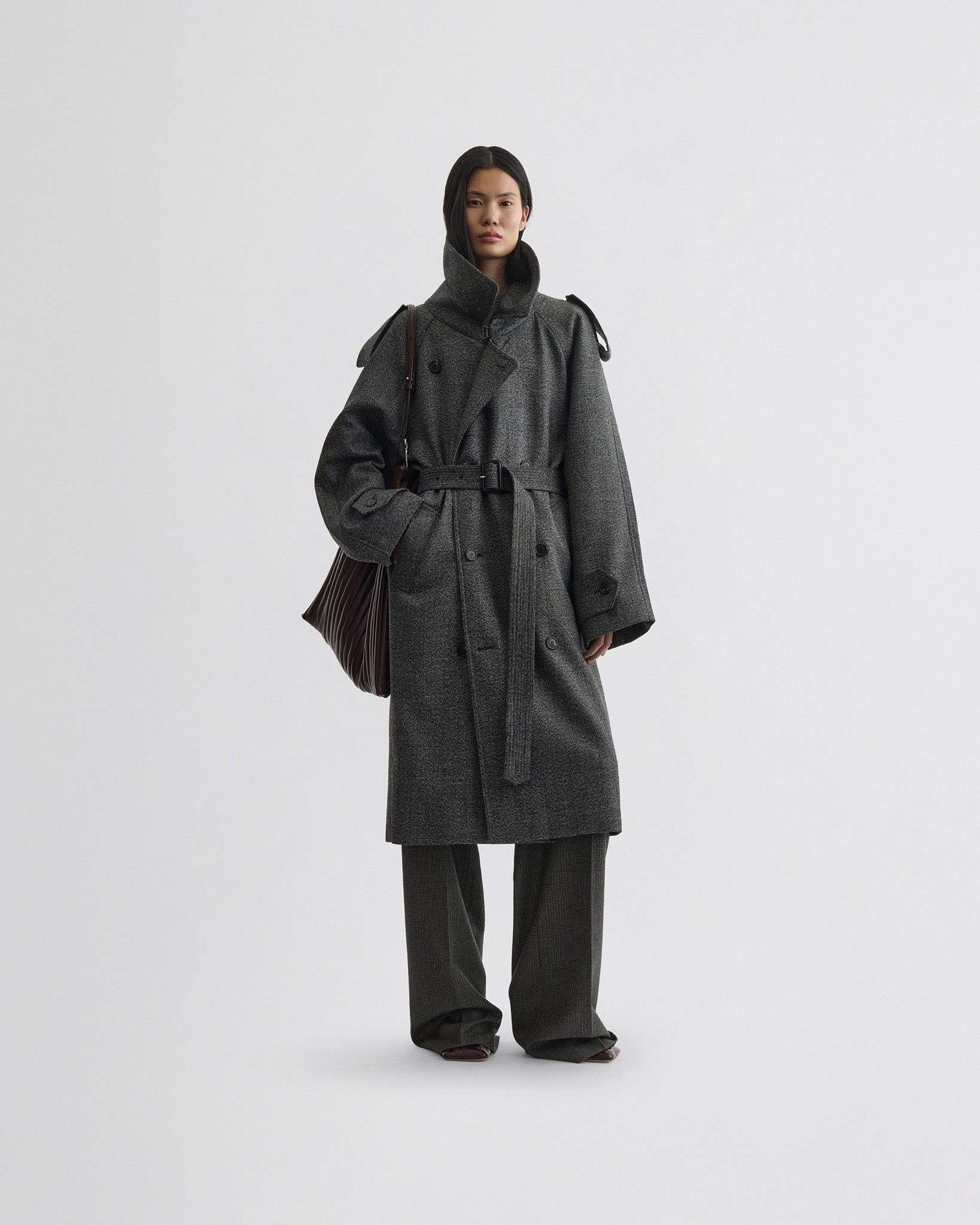 Front view of model wearing padded trench coat in salt and pepper wool.