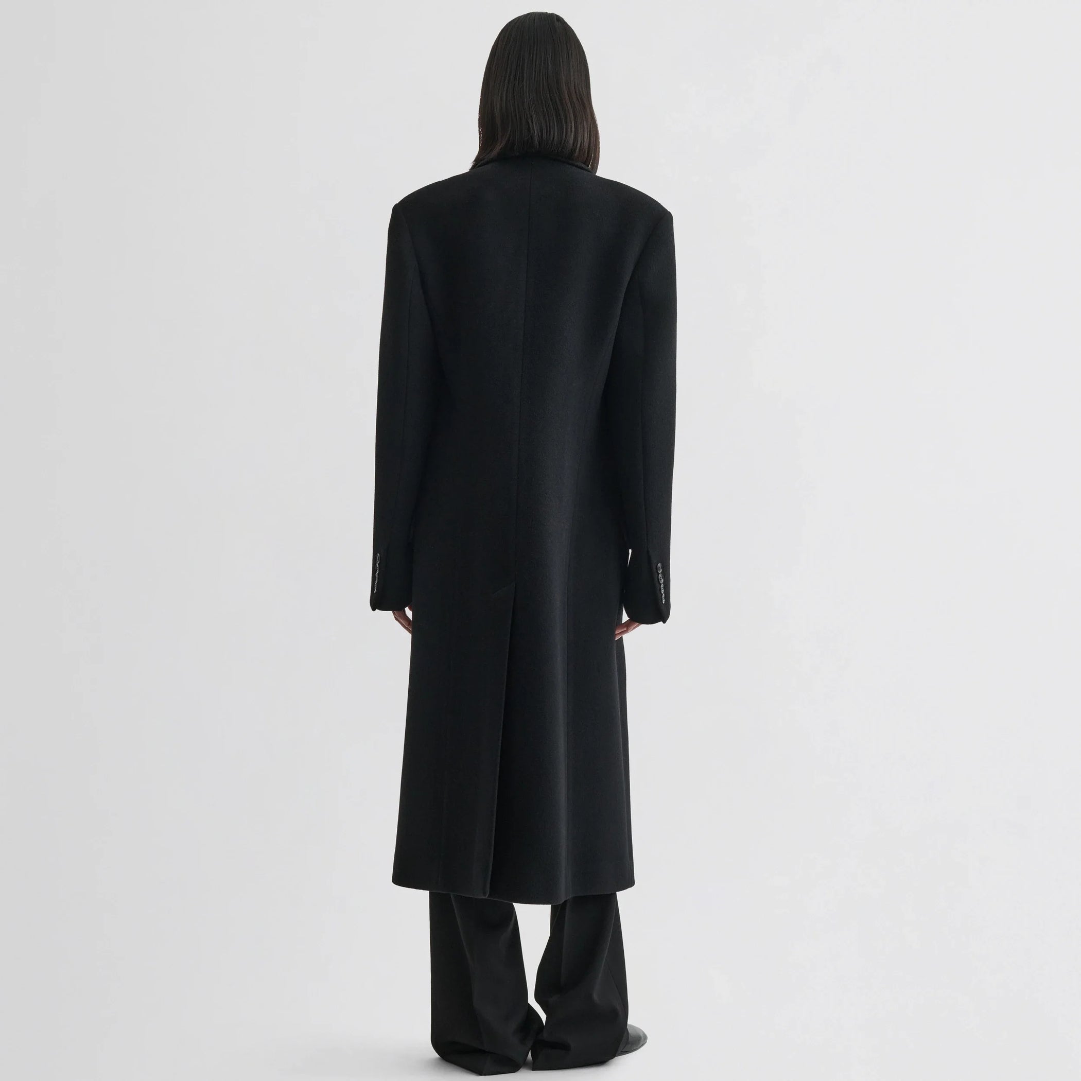 Back view of model wearing classic coat in black cashmere.