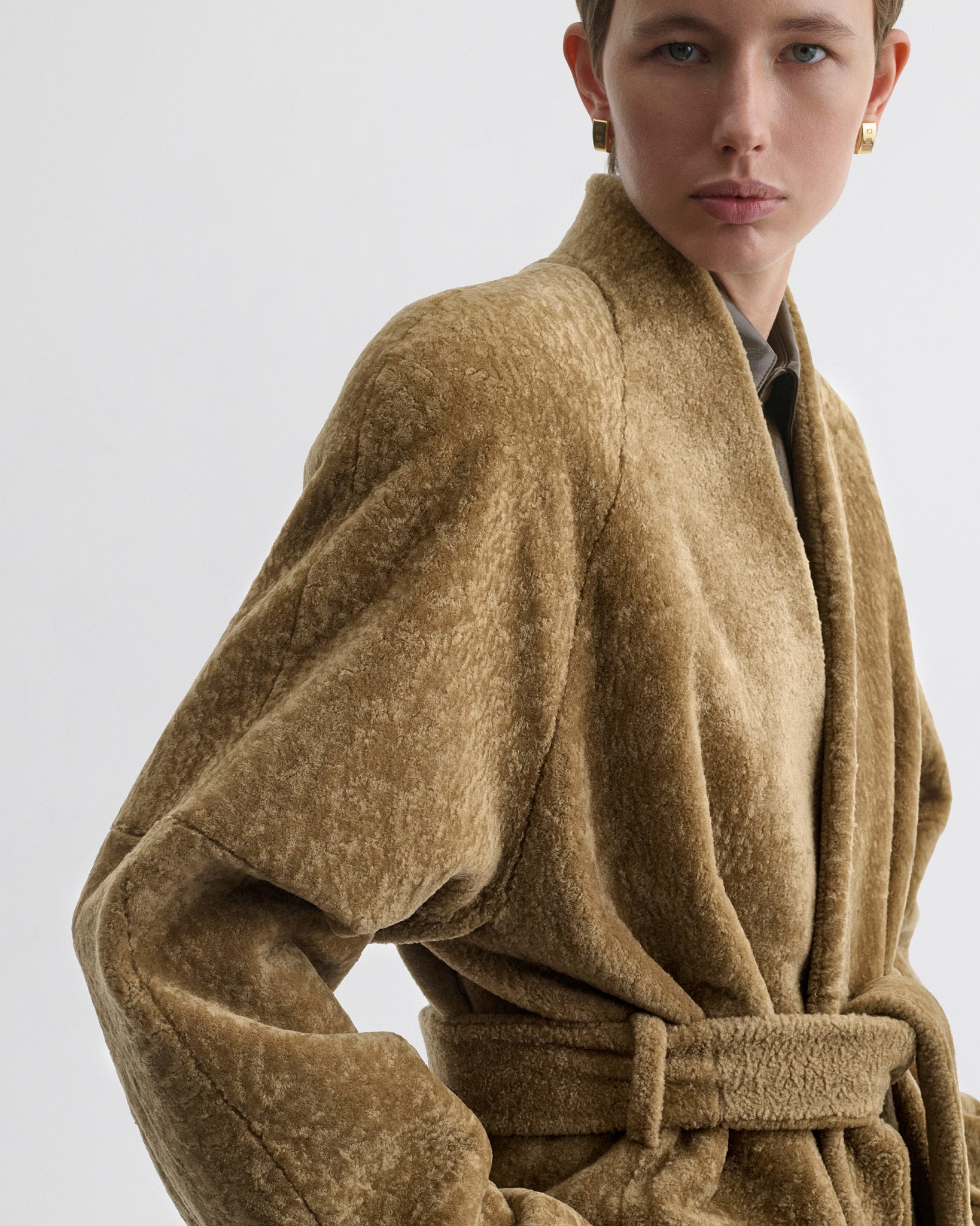 Front close up view of model wearing Shaved Robe Coat in tabac shearling