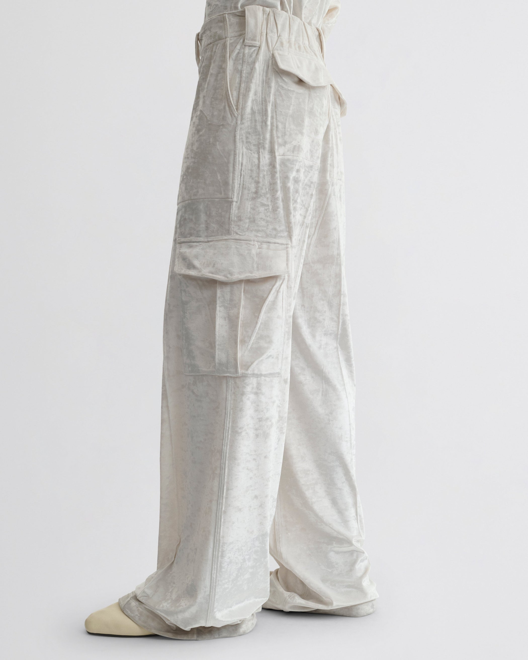 Side view of model wearing LIQUID CARGO TROUSERS  in white crushed velvet