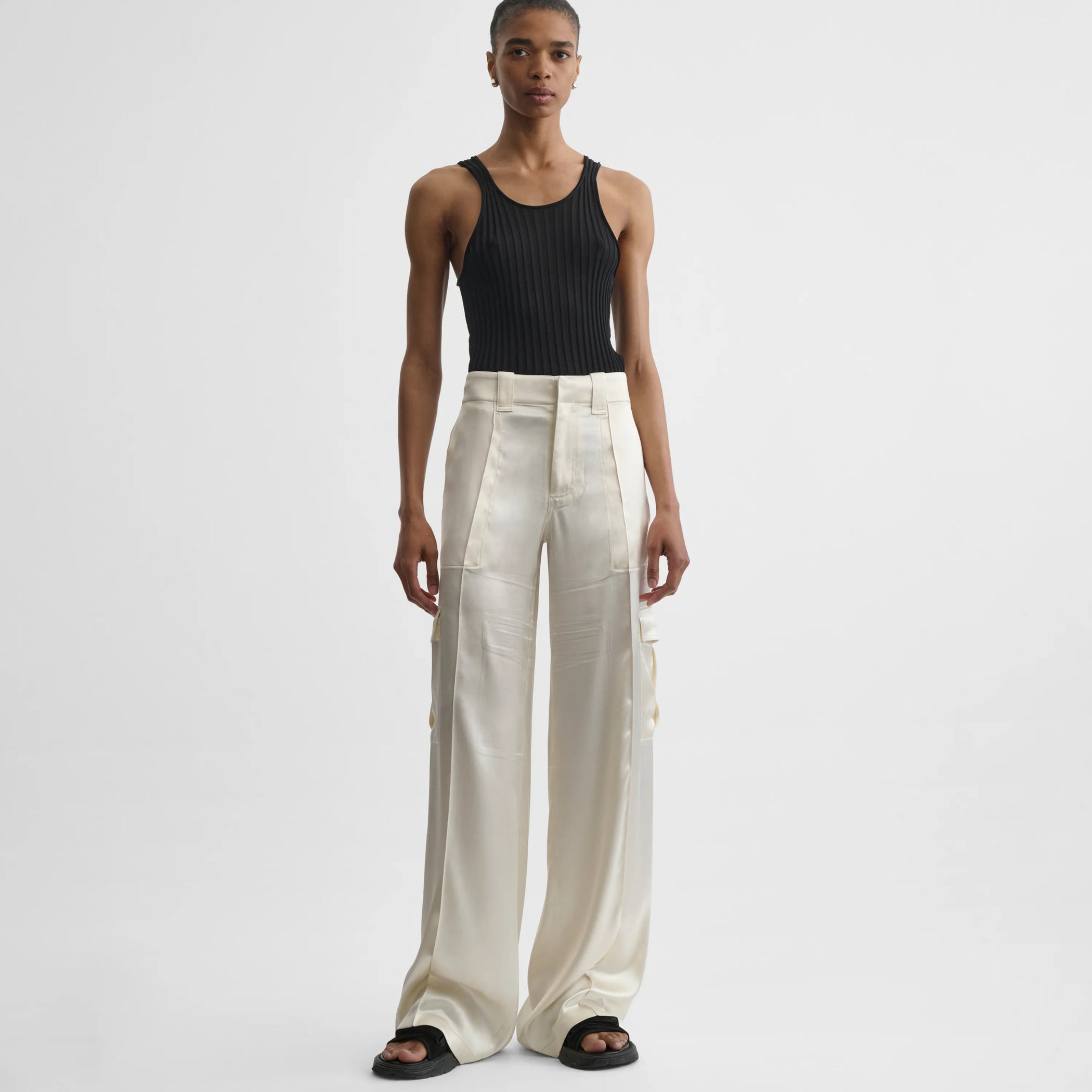 Front view of model wearing liquid cargo trousers in cream silk satin.