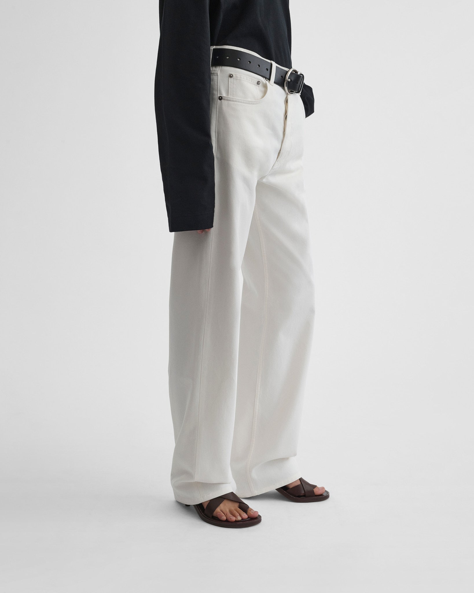 Side view of model wearing classic jeans in plaster white.