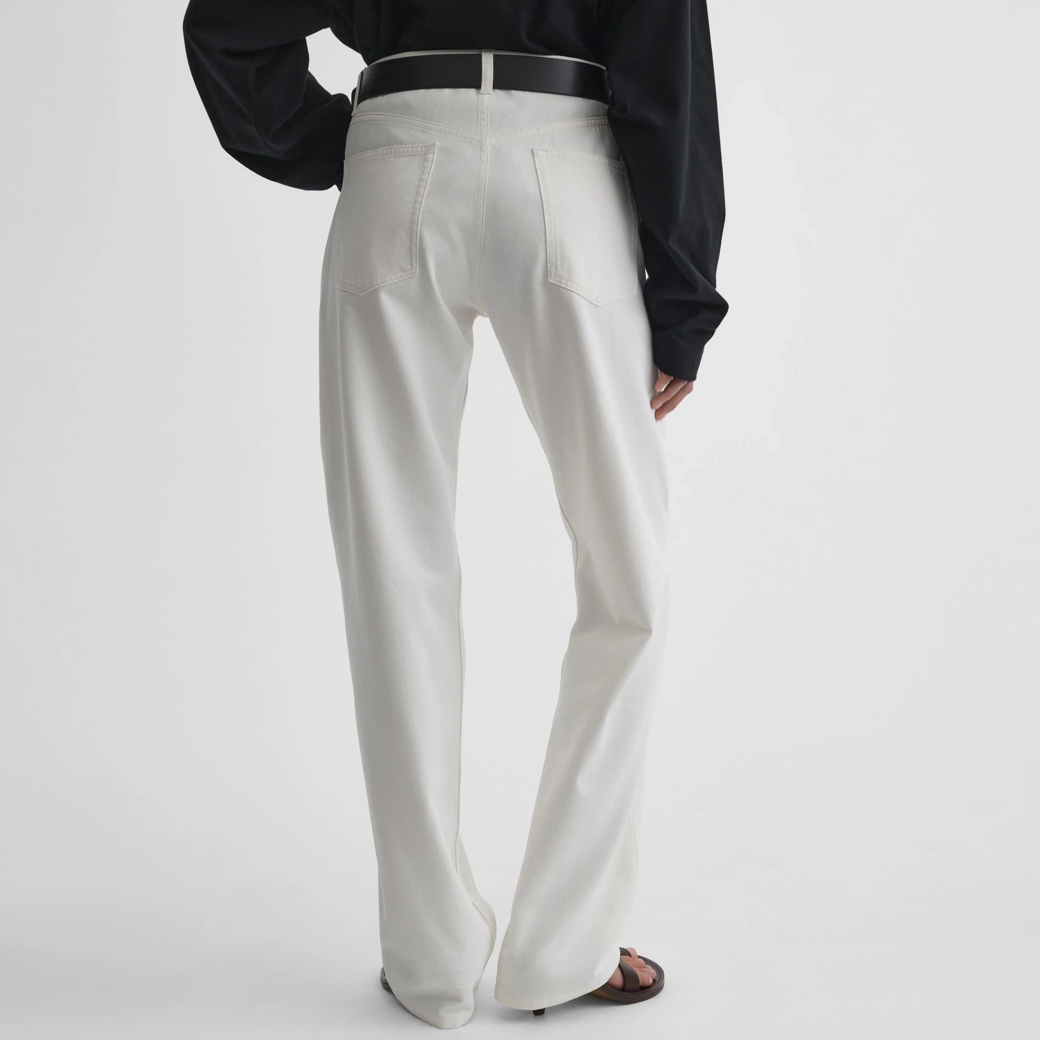 Back view of model wearing Classic Jeans in plaster white.