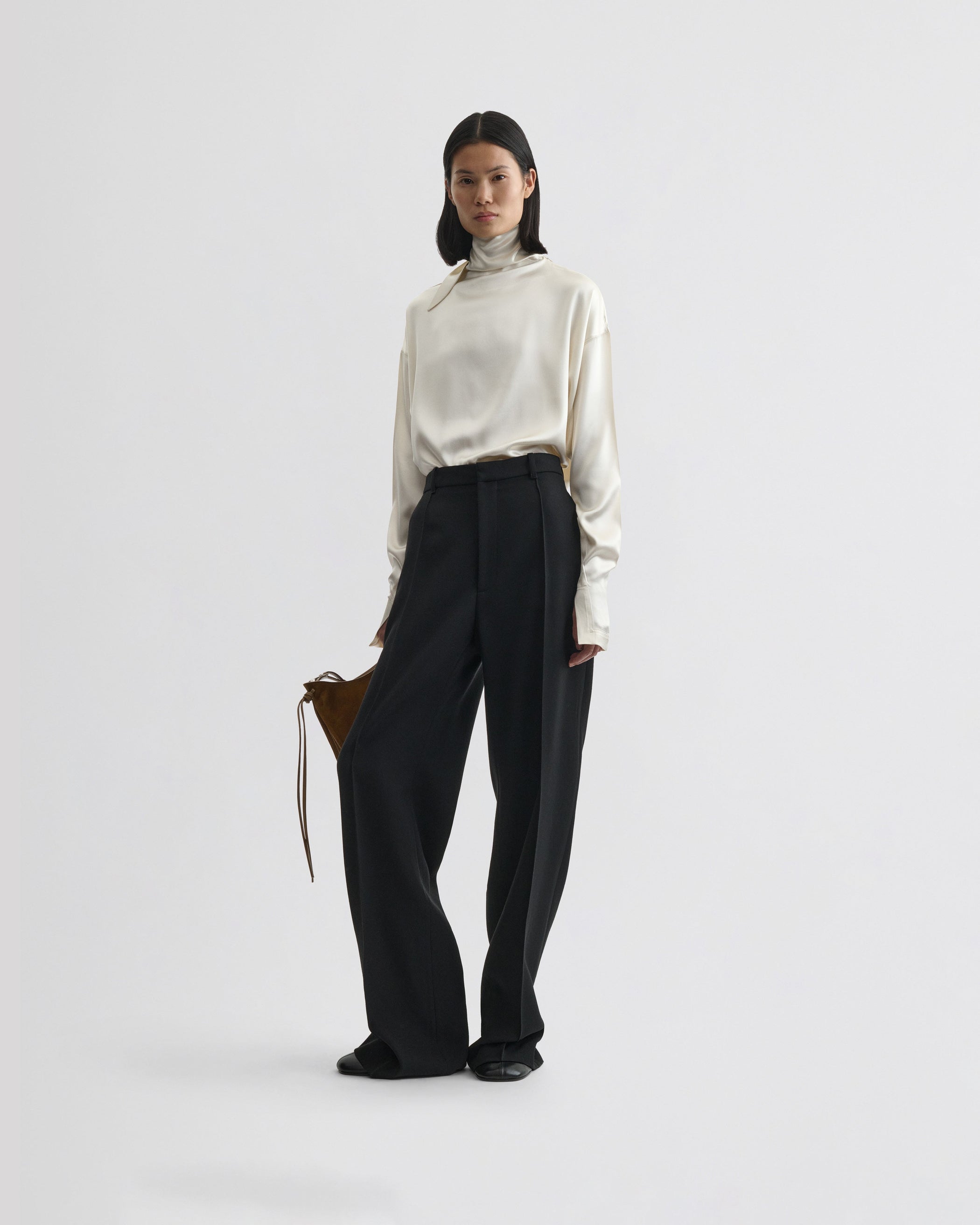 Full length front view of model wearing LIQUID KNOT COLLAR TOP in cream silk