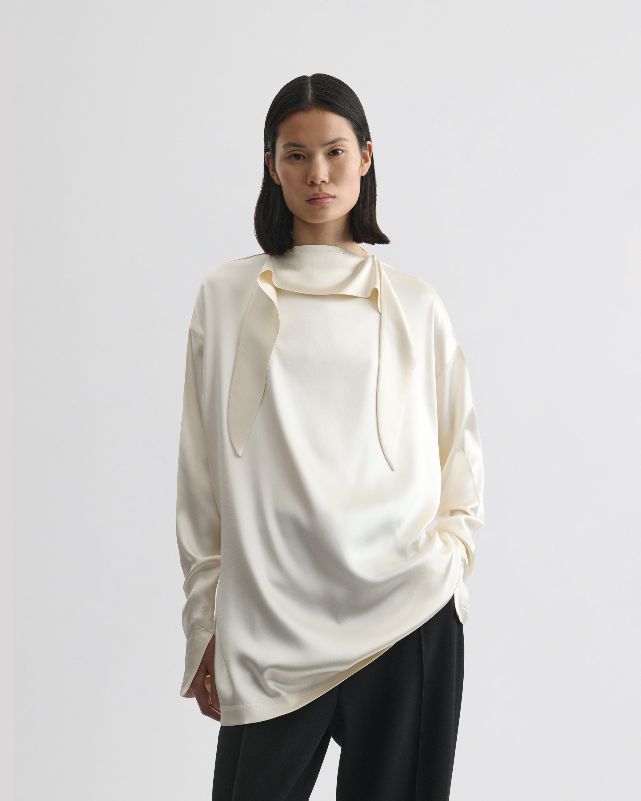 Front view of model wearing LIQUID KNOT COLLAR TOP in cream silk