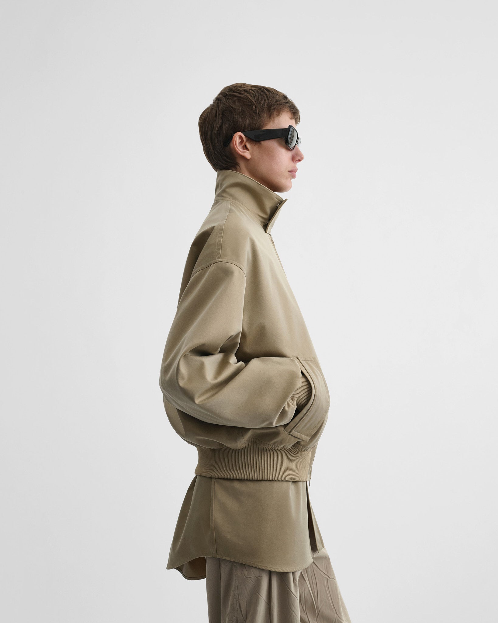 Side view of model wearing golf jacket in trench cotton.