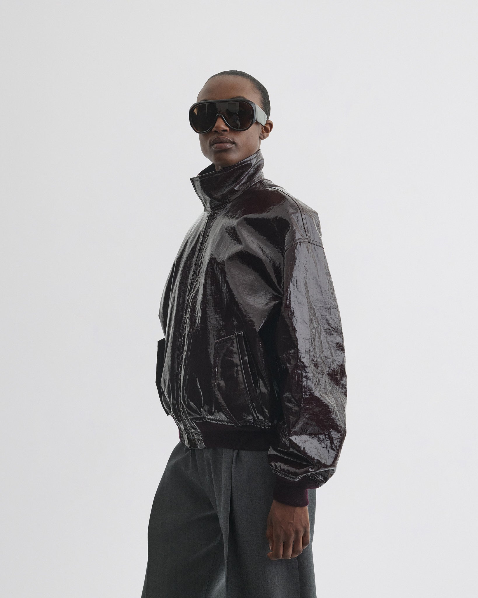 Front view of model wearing golf jacket in burgundy linen canvas.