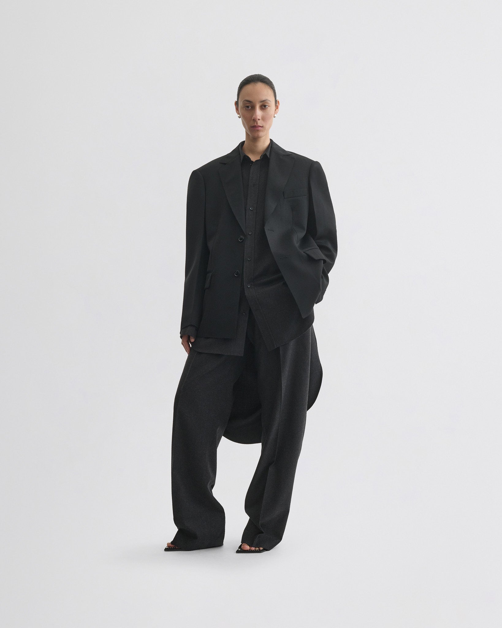 Front view of model wearing tuxedo jacket in black wool
