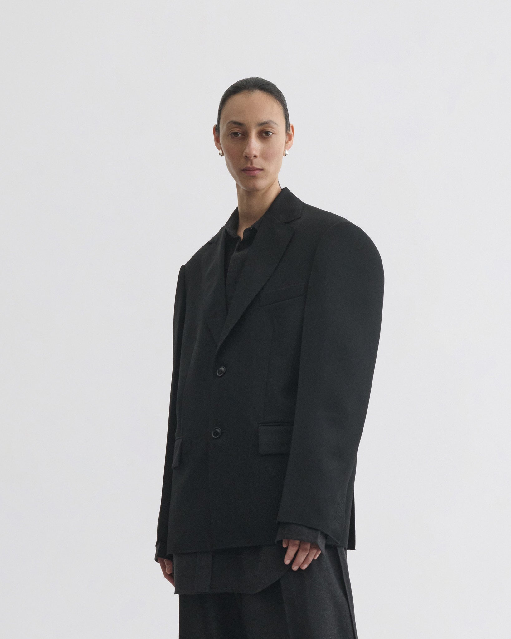 Front view of model wearing tuxedo jacket in black wool