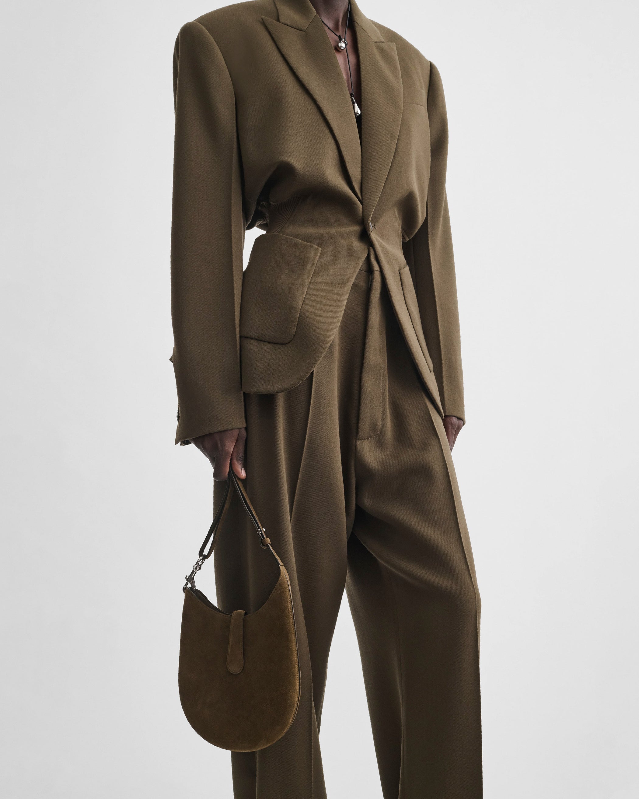 Model holding MINI BEAN SLING in olive suede