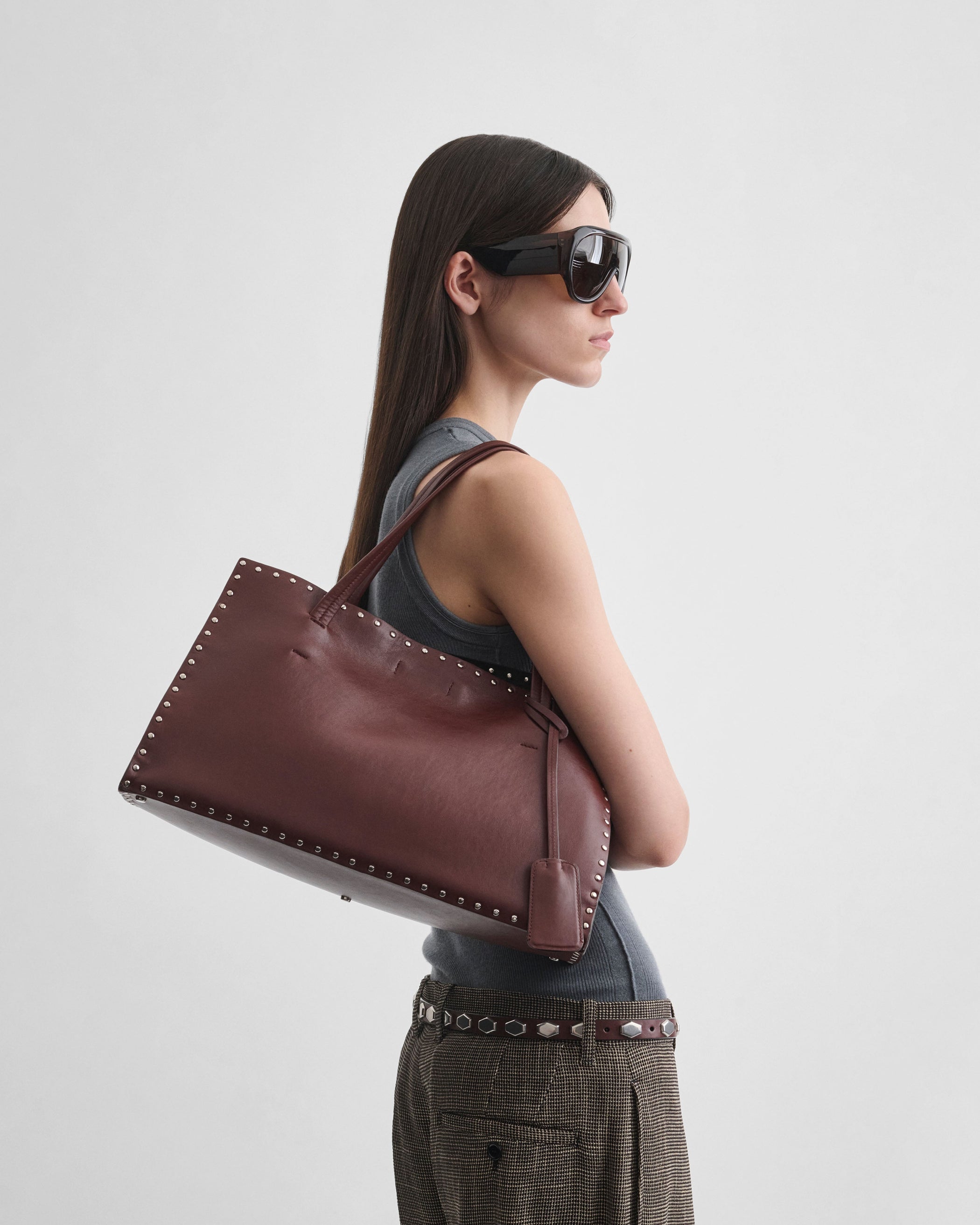 Side view of model wearing SMALL STUD CABAS in chestnut leather