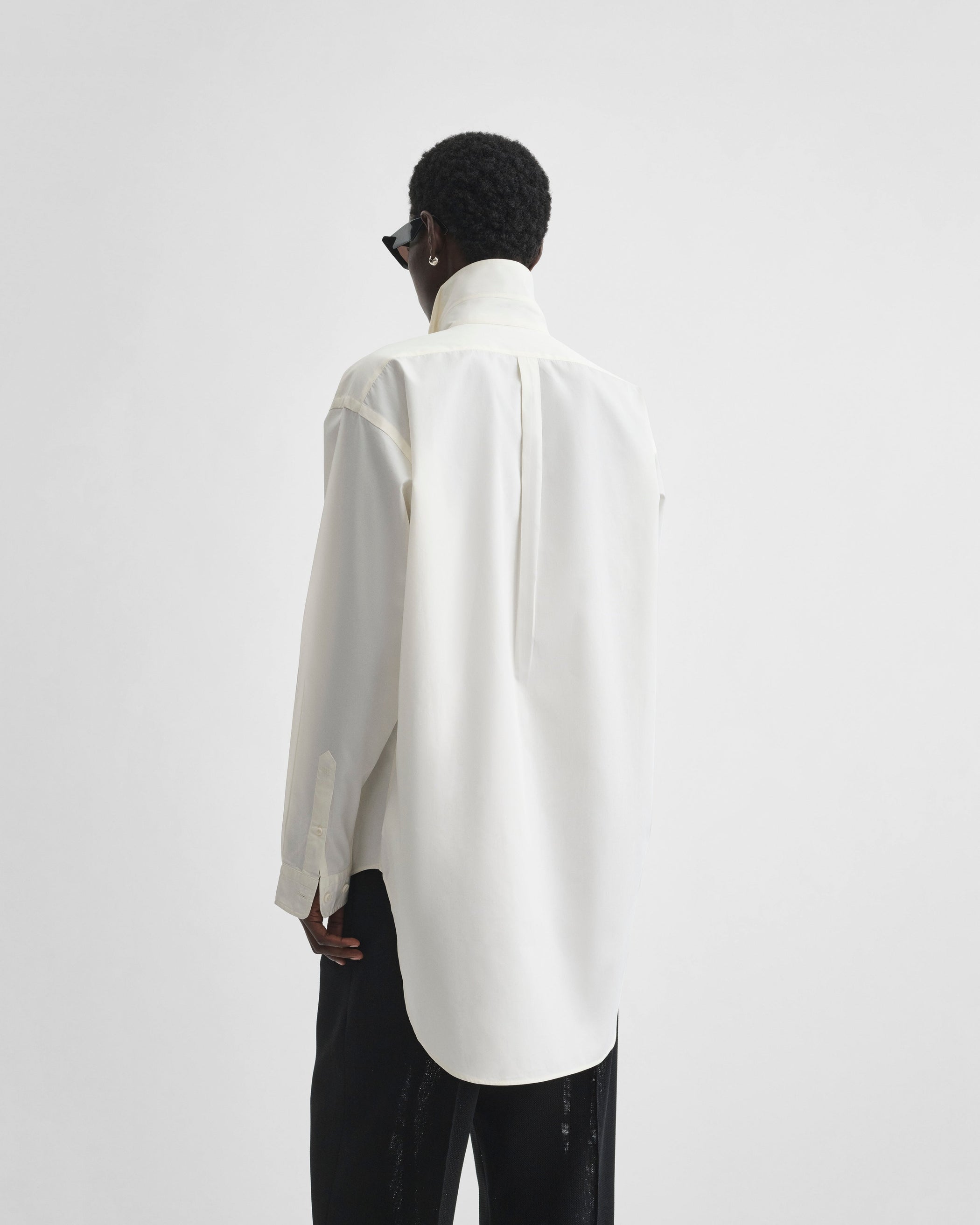 Back view of model wearing CLASSIC SHIRT in cream cotton