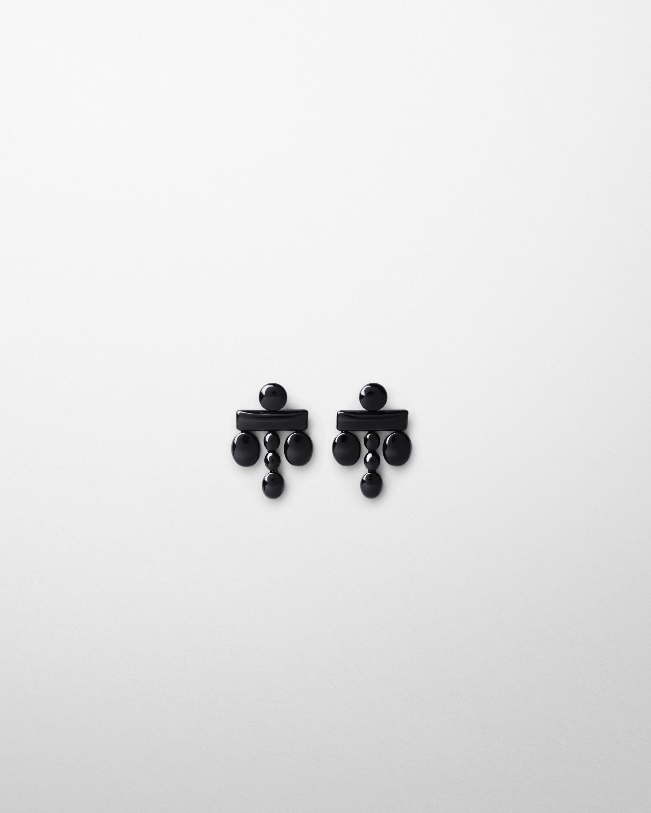 Flat front view of DROPLET CHANDELIER EARRINGS in black