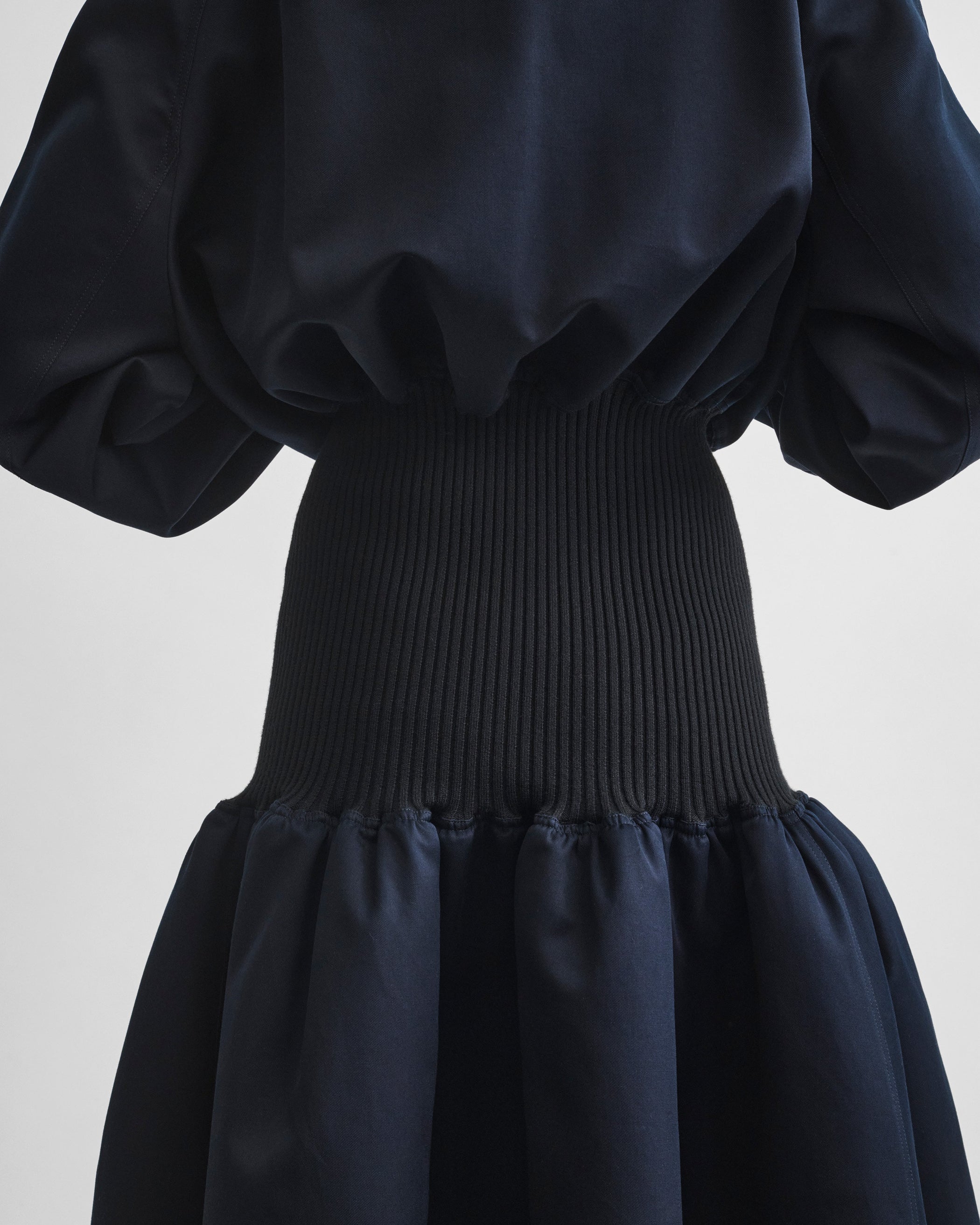 Back detail view of model wearing KICK COAT in dark navy cotton