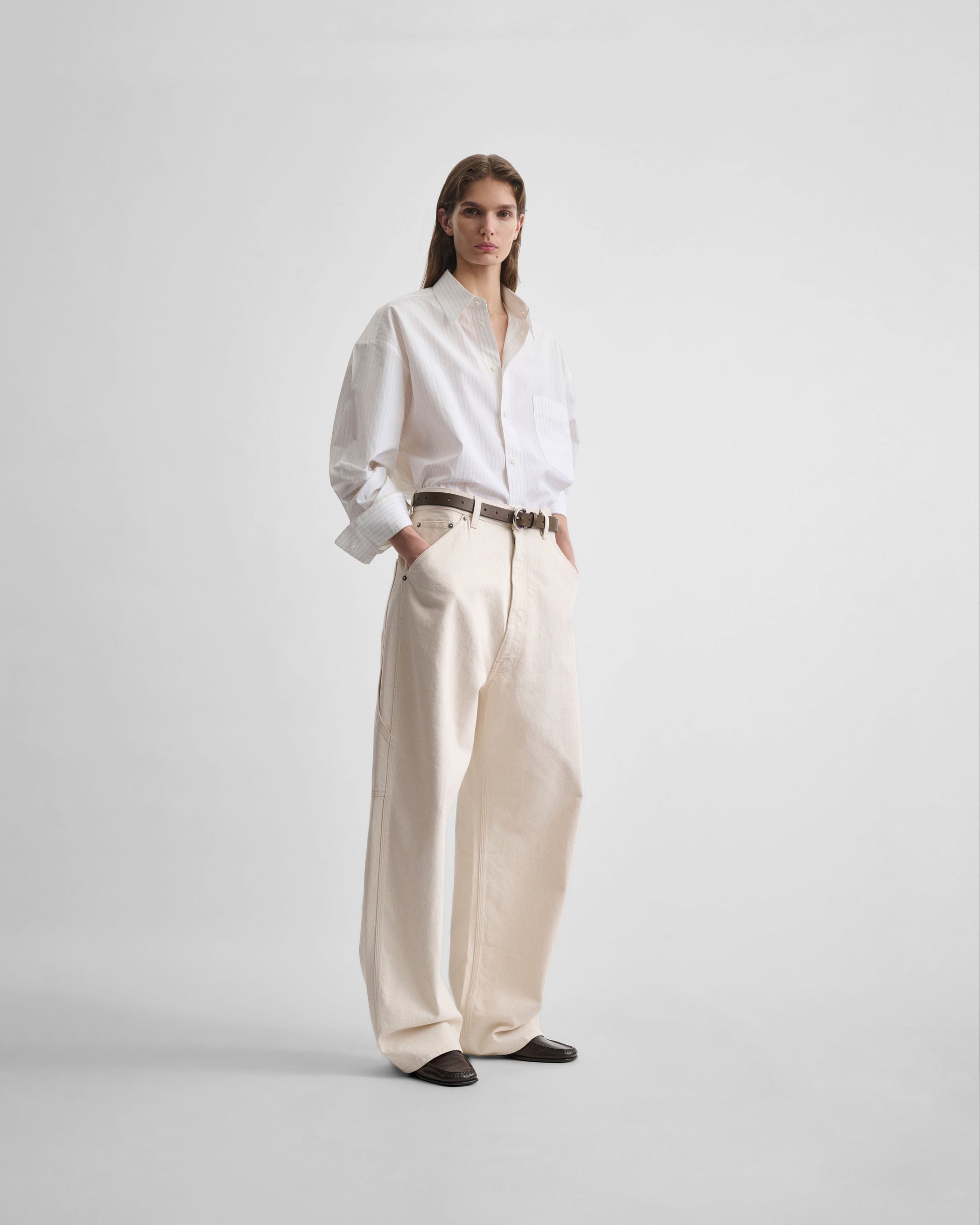 Full length front view of model wearing CARPENTER JEANS in cream cotton