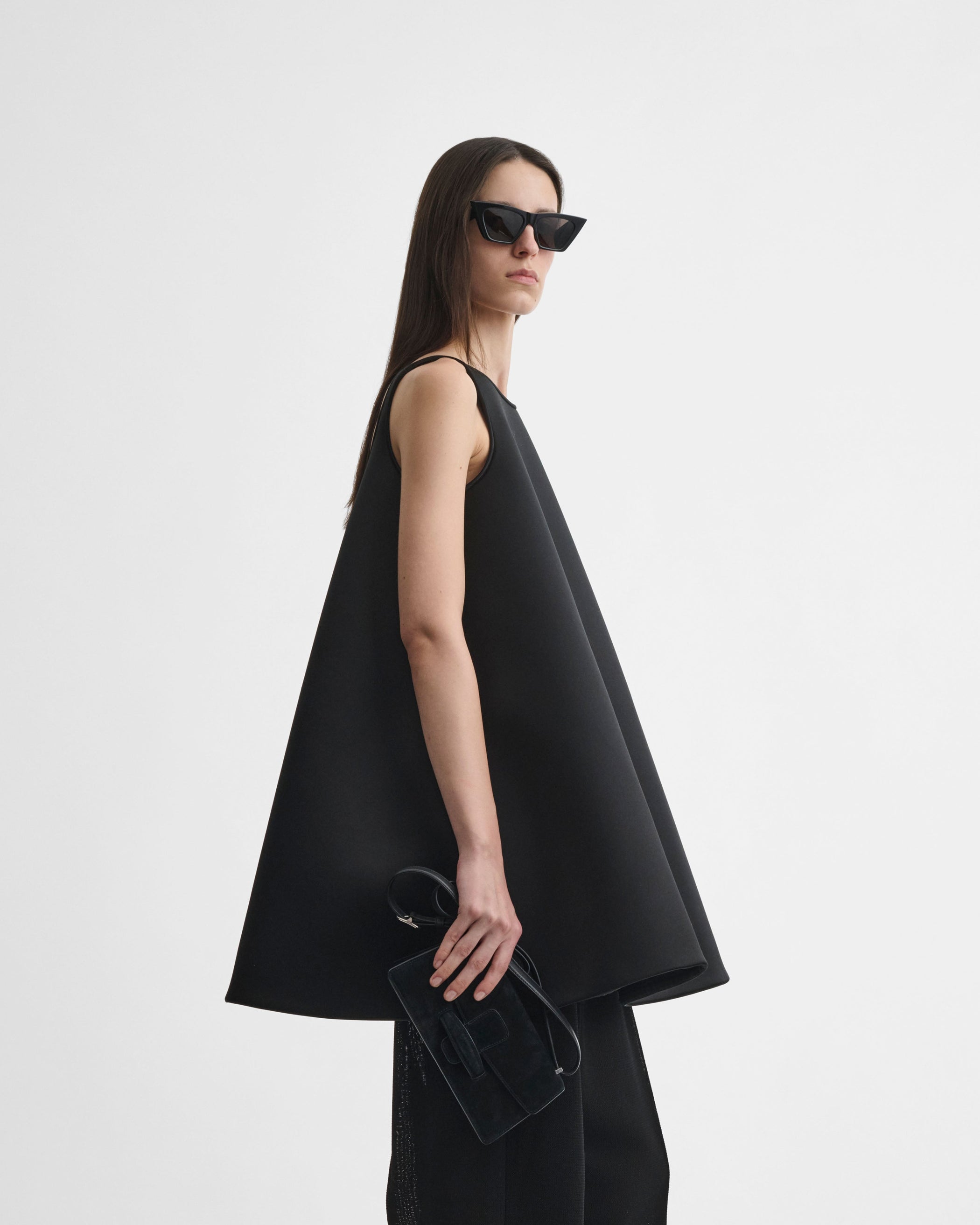 Side view of model wearing A TANK TOP in black silk