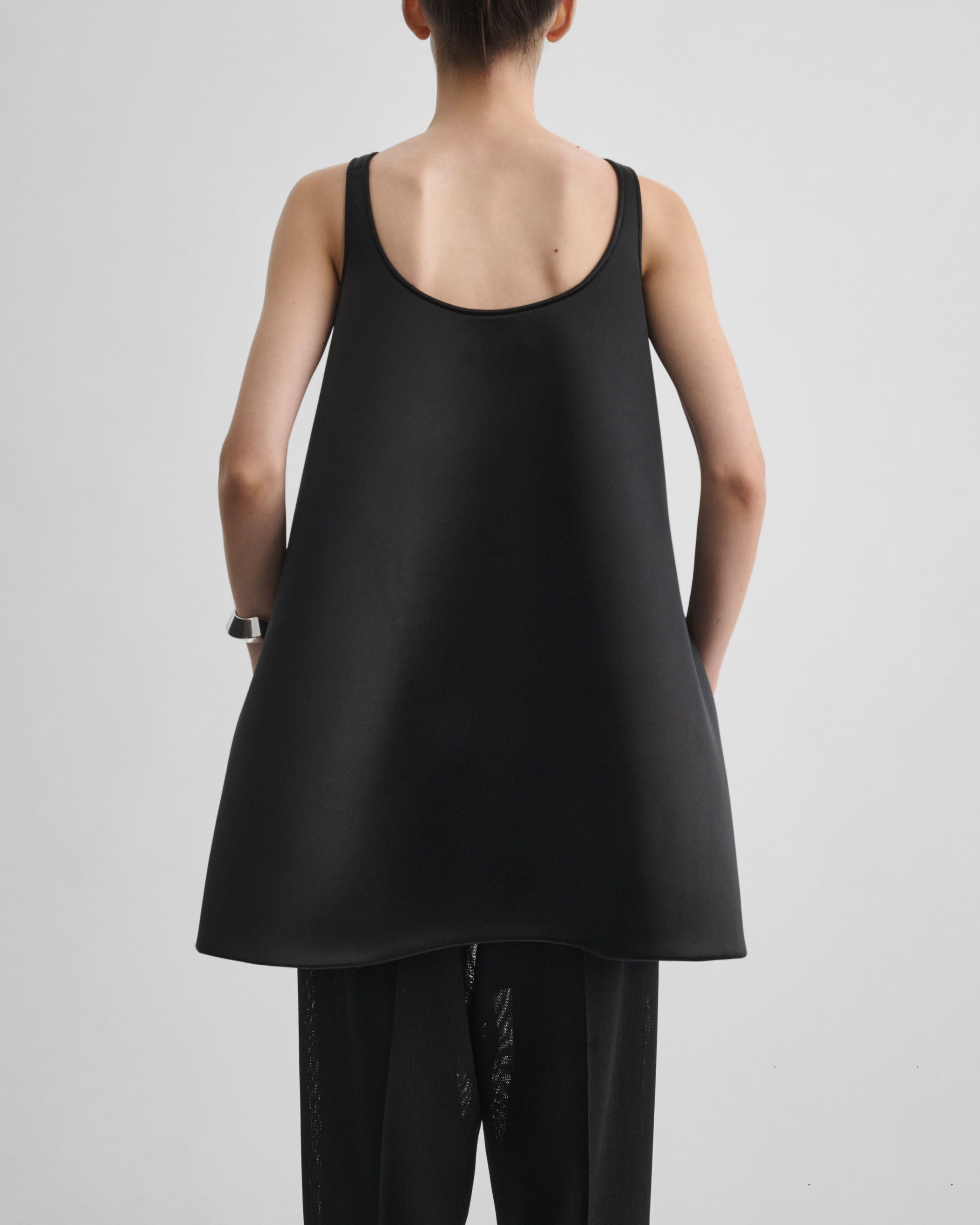 Back view of model wearing A TANK TOP in black silk