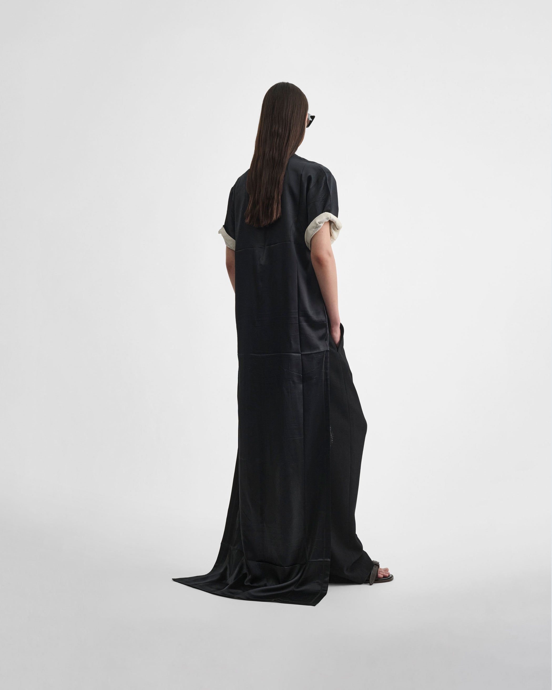 Angled back view of model wearing GRAPHIC TRAIN TEE in black silk