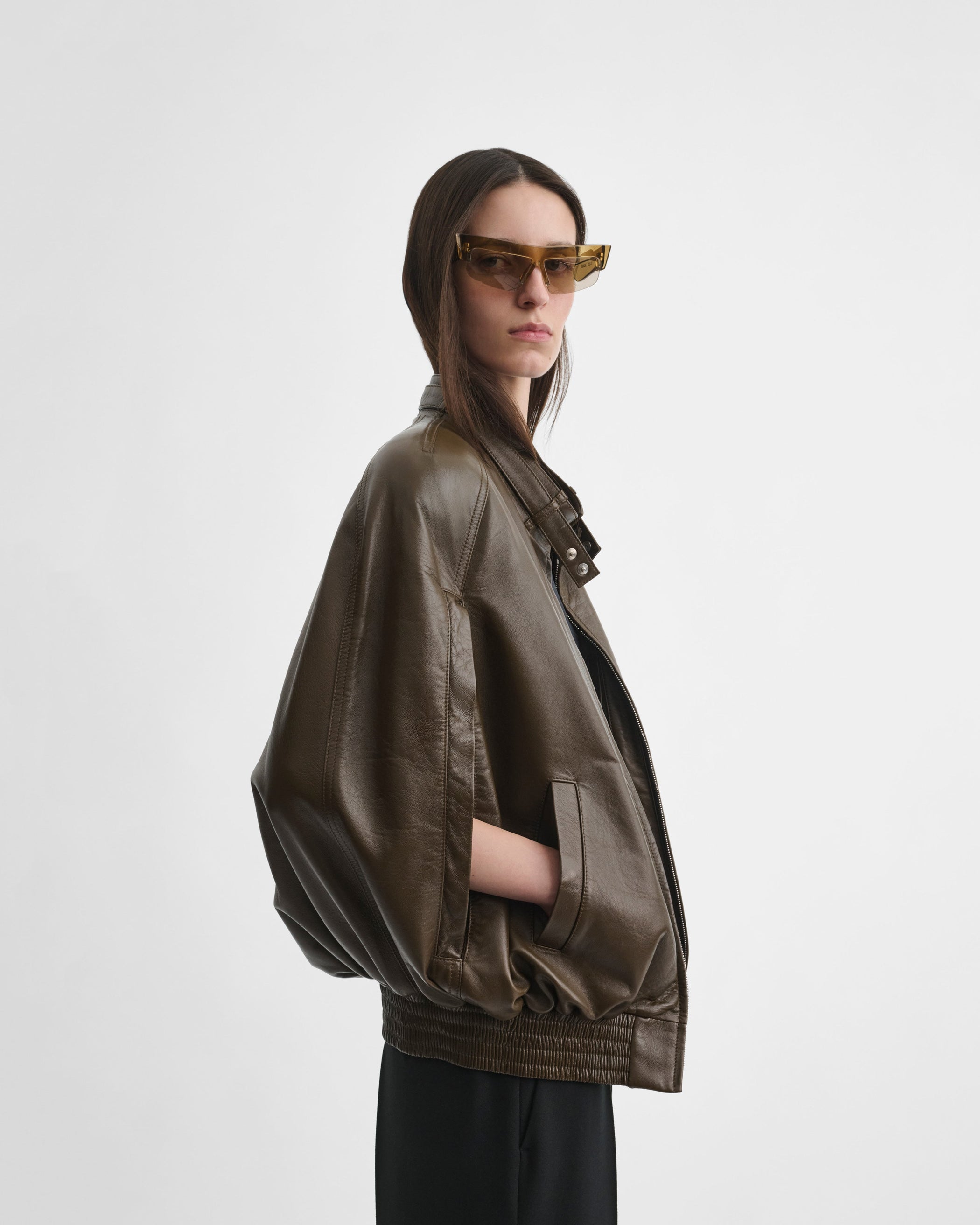 Side view of model wearing CAPE BOMBER in green bronze leather