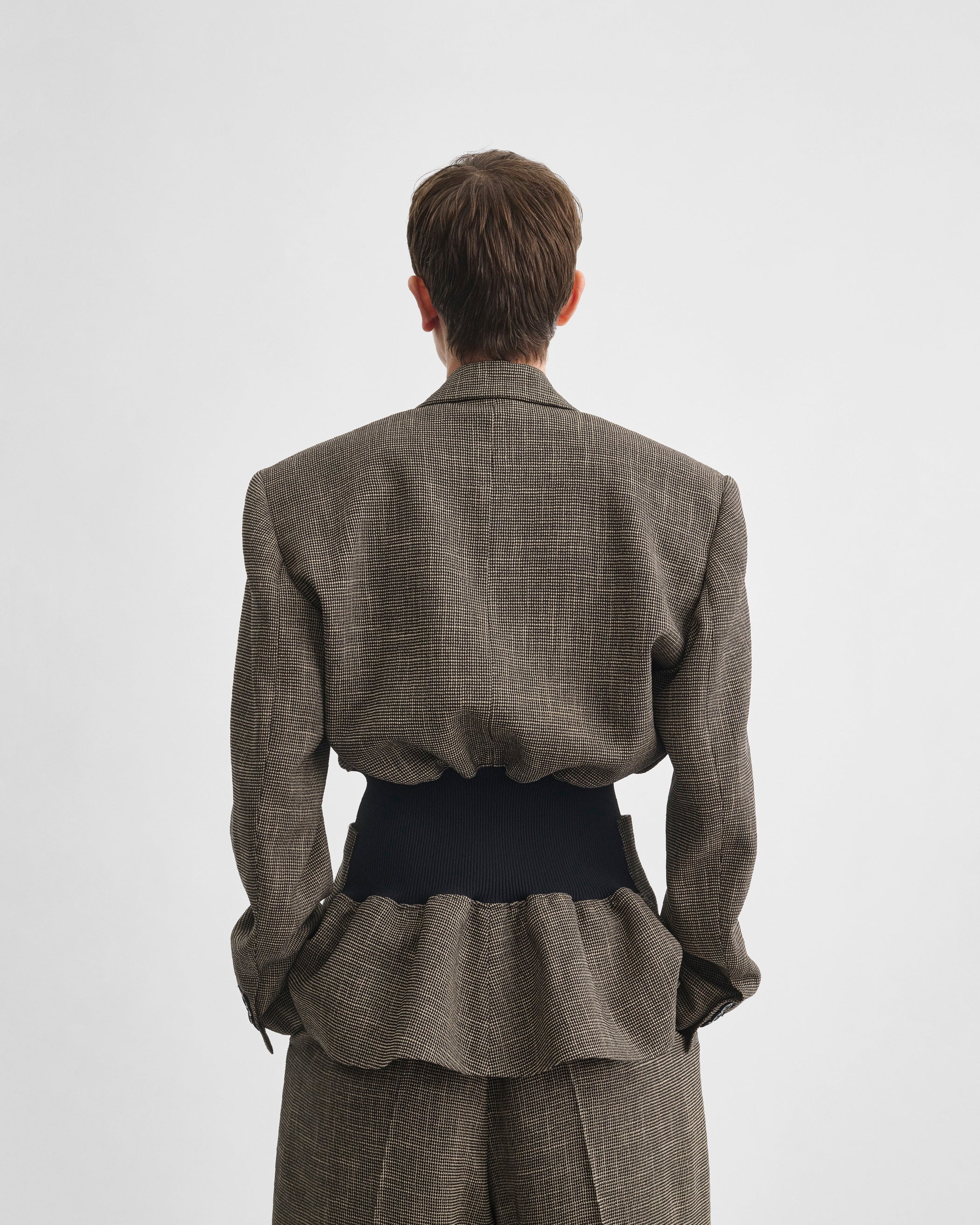 Back view of model wearing KICK TAILORED JACKET in salt and pepper viscose