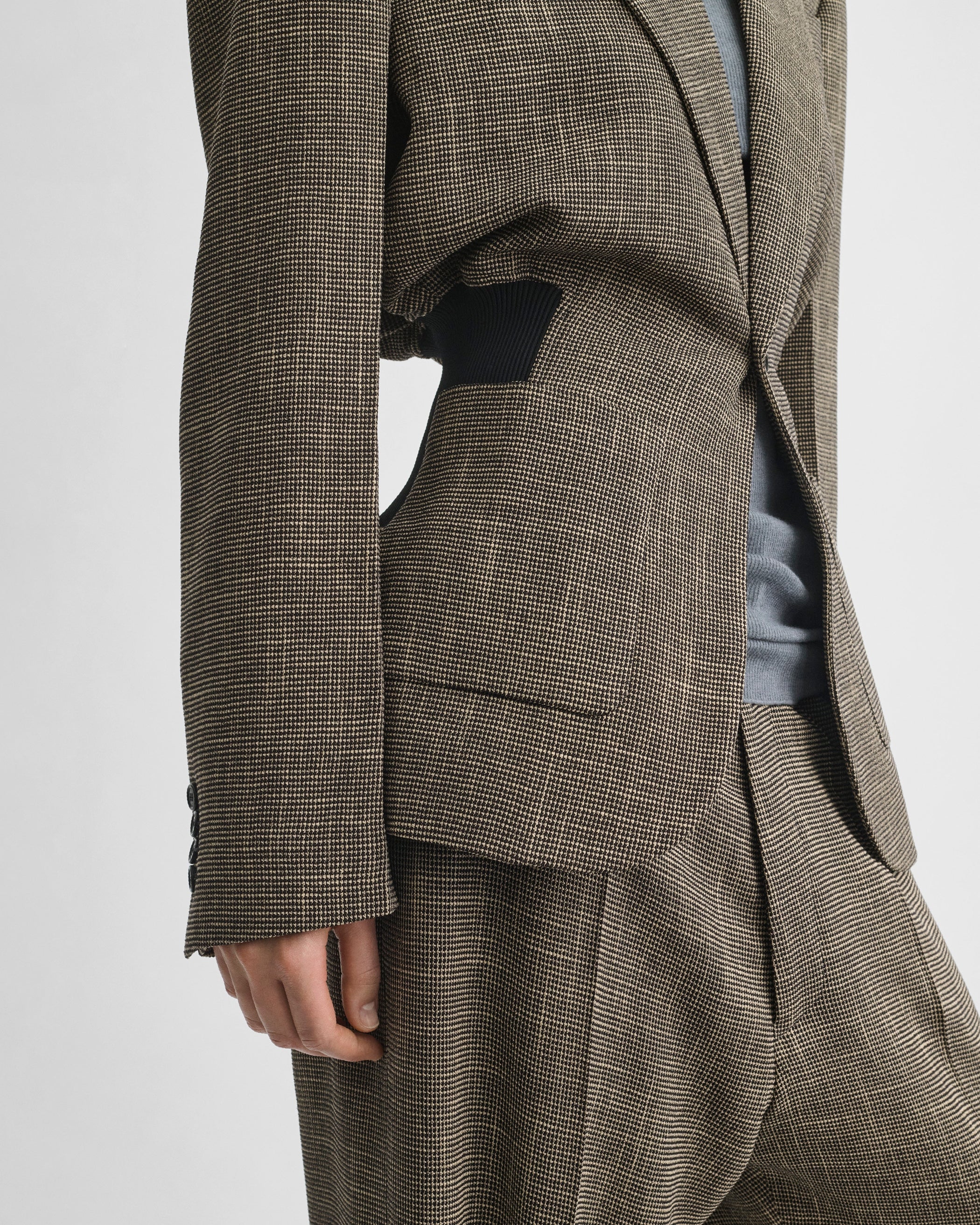 Side detail view of model wearing KICK TAILORED JACKET in salt and pepper viscose