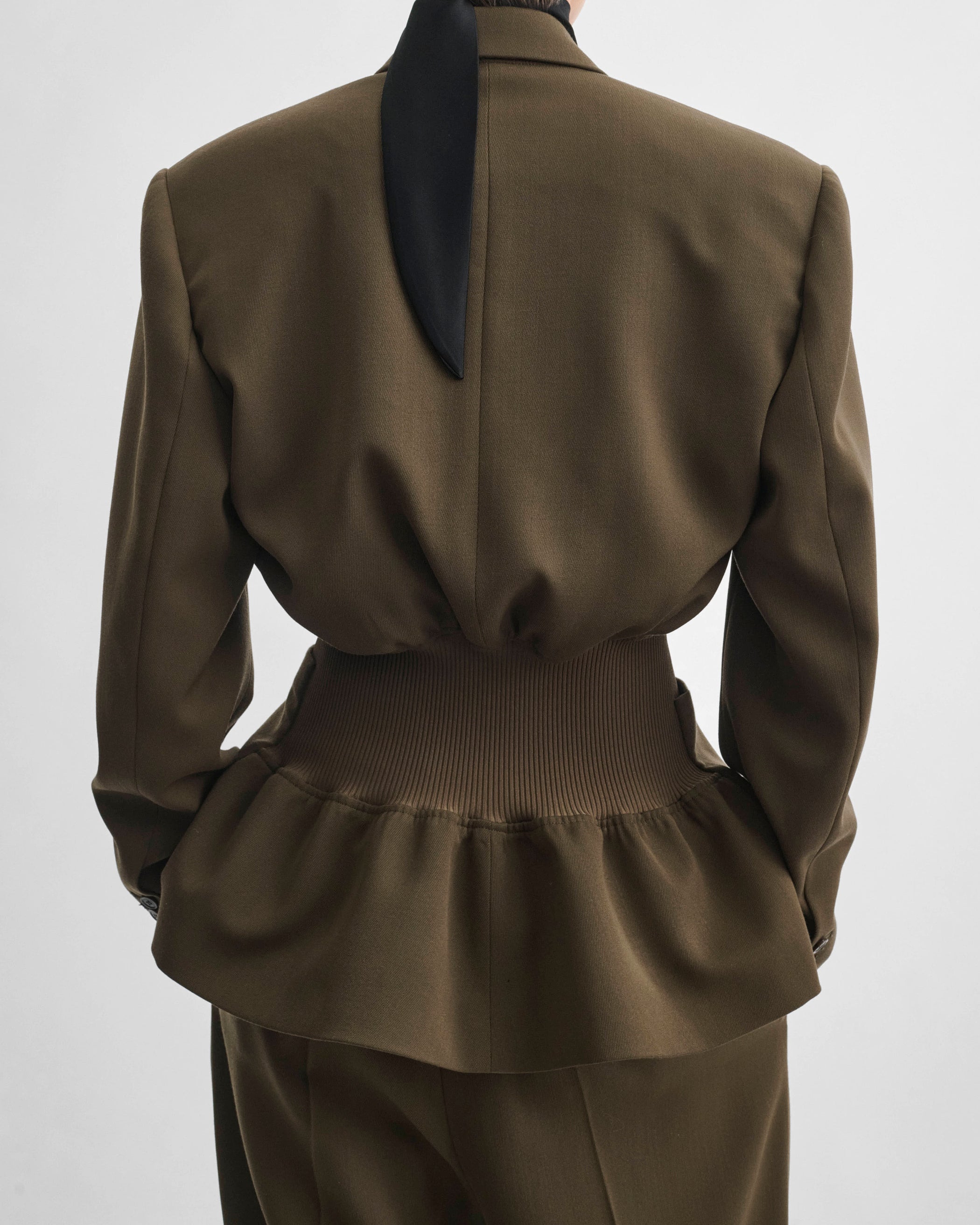 Back view of model wearing KICK TAILORED JACKET in shroom wool